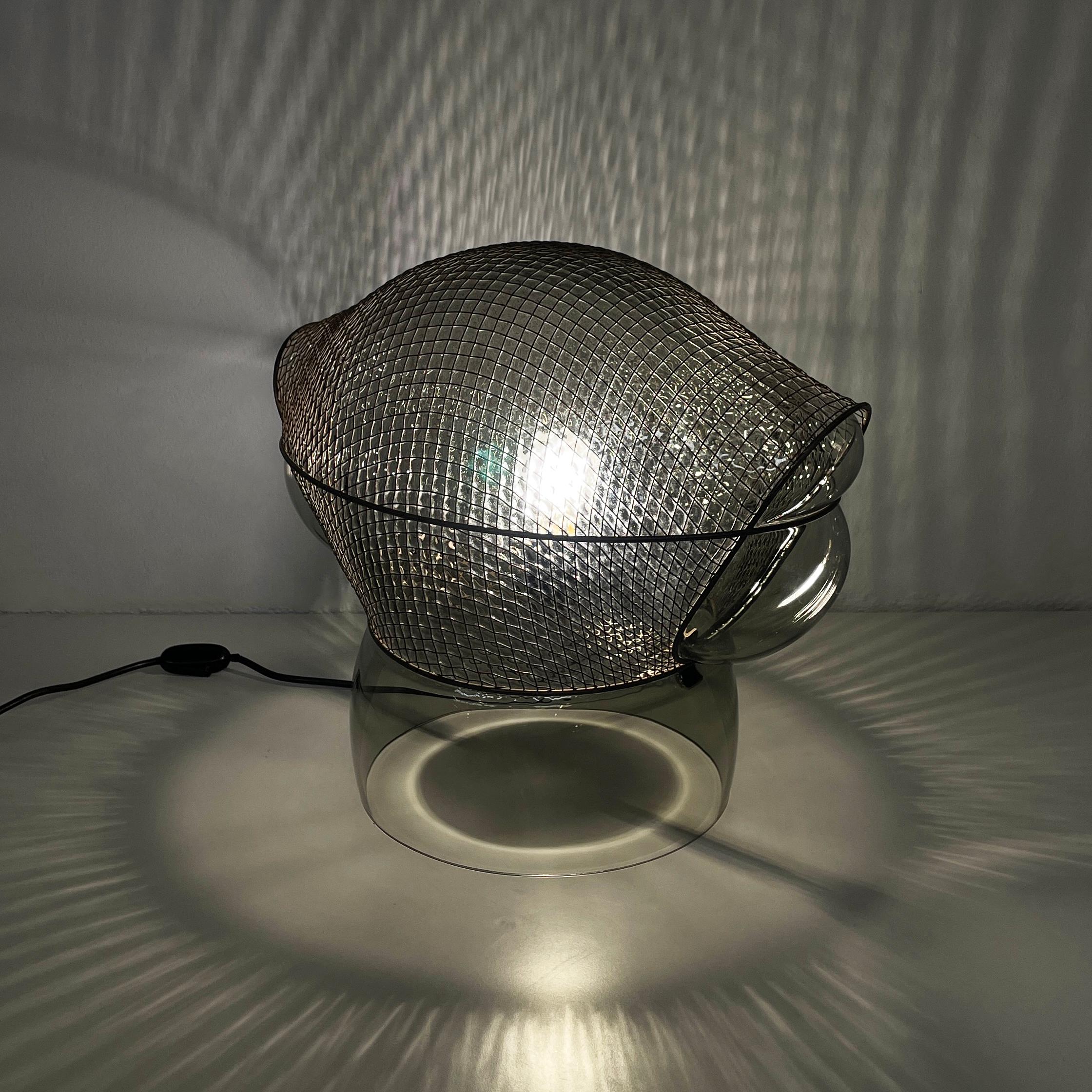 Moderne italienische Tischleuchte aus Glas und Stahl Patroclo von Gae Aulenti für Artemide, 1970er Jahre
Tischlampe Mod. Patroclo aus Glas und Stahl. Der abgerundete Glasdiffusor ist mit einem Metallnetz überzogen. Sockel mit Glaskuppel.
Produziert