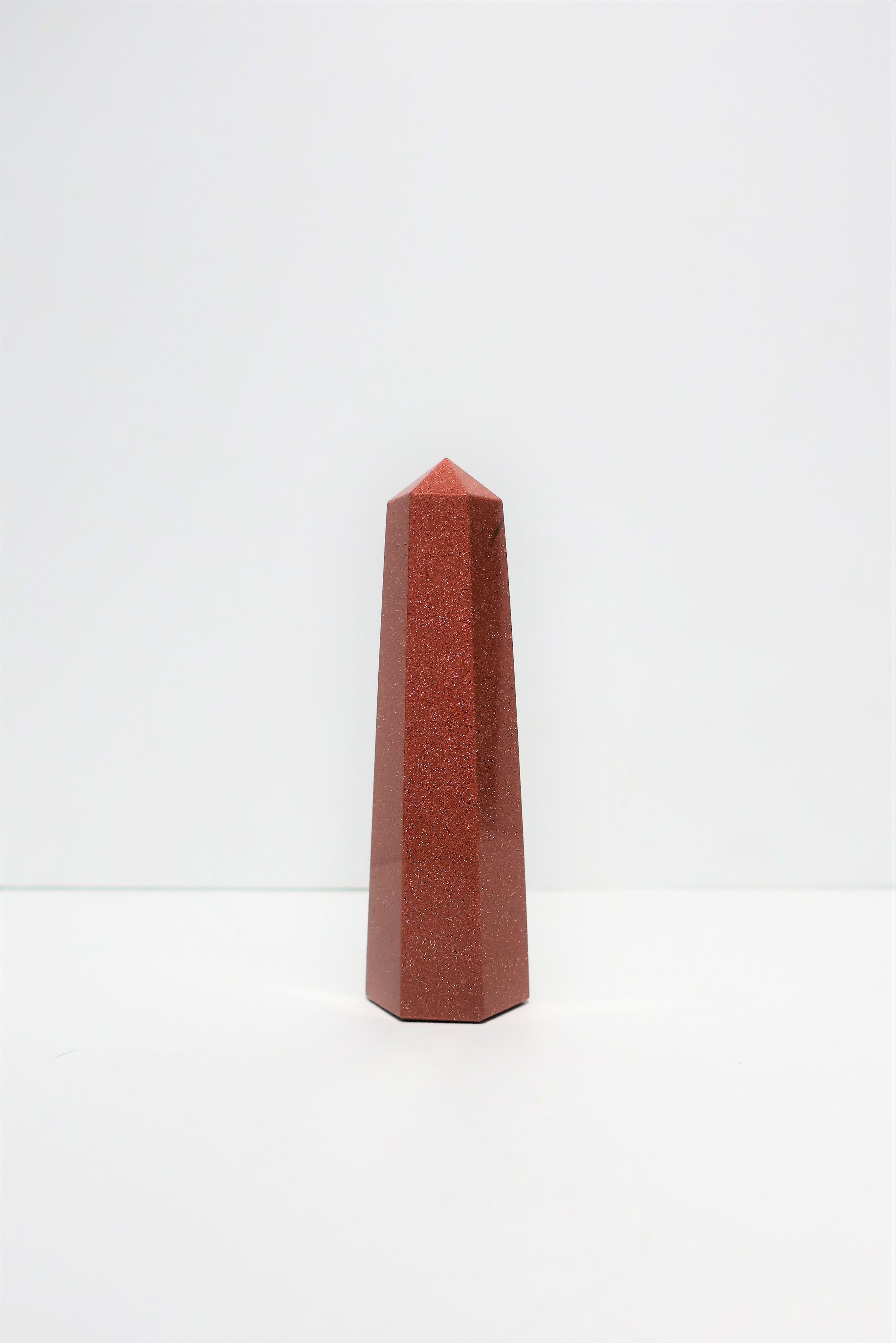 An Italian modern style goldstone art glass Obelisk in a hexagon design, circa late 20th century, Italy. This goldstone piece is a shimmering metallic copper or terracotta colored art glass, cut and polished smooth. 

Measures: 1.5