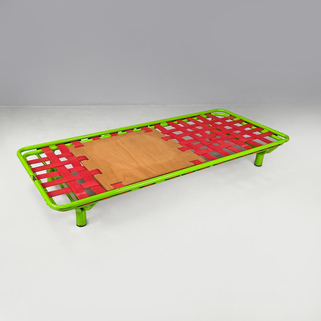 Italian modern green daybed or bed in metal and wood with red straps, 1980s
Single bed or daybed with tubular metal structure painted bright green. The net is made up of a crisscross of red plastic straps, which fit into the structure with black