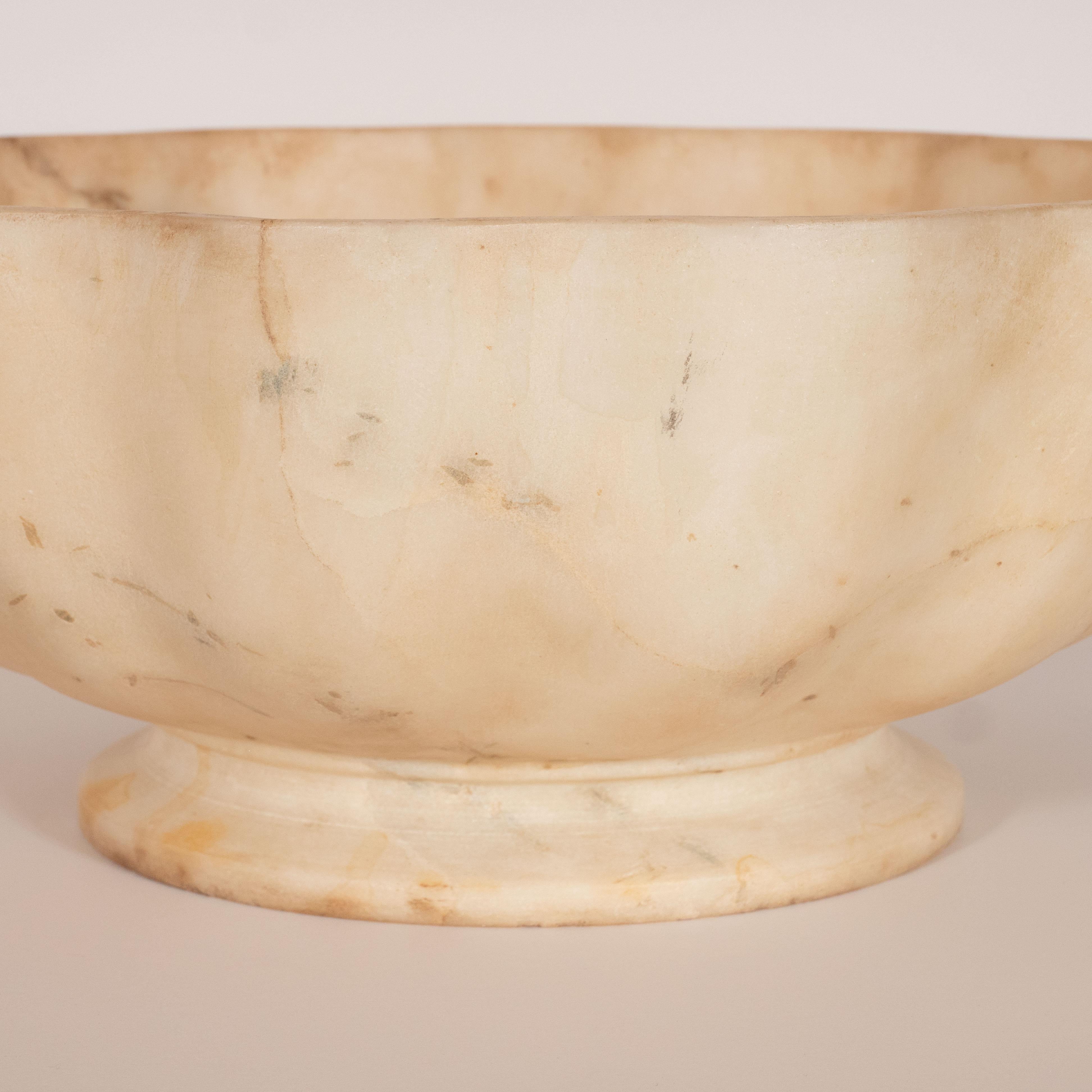 This refined marble bowl was hand-carved in Italy. It features a circular base and scalloped sides in exotic marble with variegated muted tones of oatmeal, cocoa and cream. With its austere form and beautiful natural stone grain, this piece would be