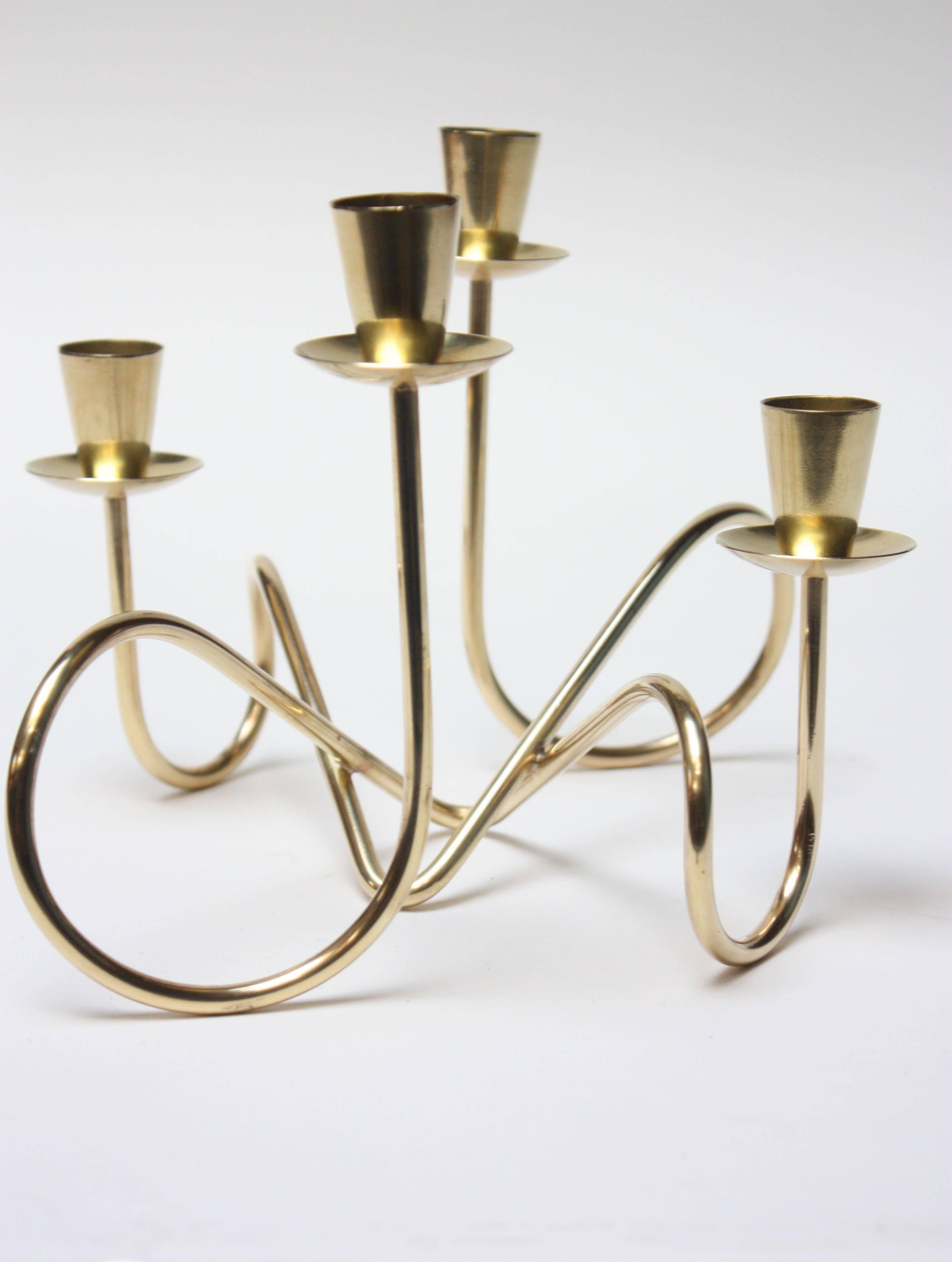Elegant decorative object composed of two entwined brass candleholders to form one, larger sculptural candelabra which accommodates four candles. Excellent, polished condition with only the minor traces of use / wear, circa 1950s, Italy (branded