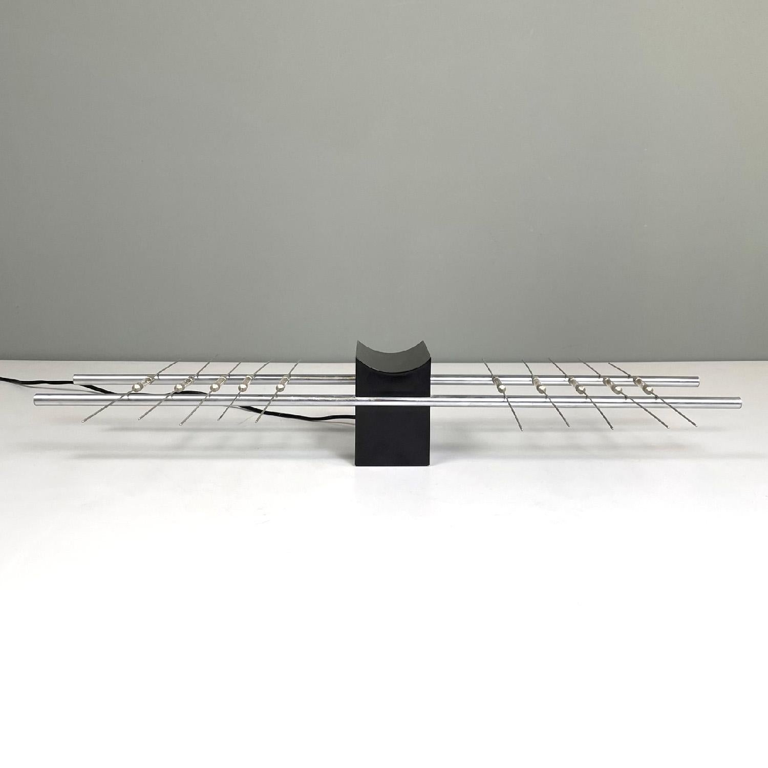 Lampe de table magnétique moderne italienne par Theodore Waddell pour Zanotta, 1971
Lampe de table à allumage magnétique. La base centrale est une structure à base rectangulaire avec un sommet convexe en plastique noir. Quatre tiges métalliques