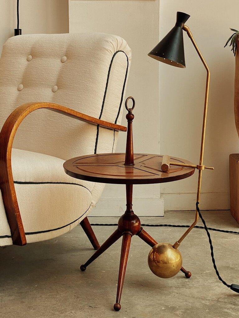 A three legged Italian Modern “Martini” side table in the manner of Cesare Lacca with a leather top and a brass ring holder.

Measures: 24” H x 16.5” W Shelf: 15.35” H.