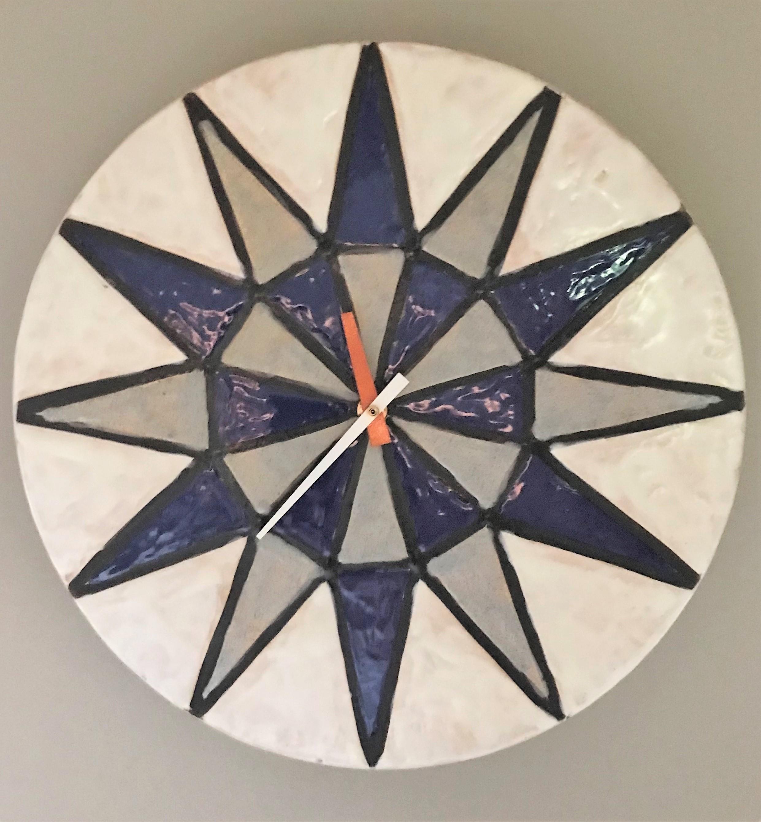 Seldom seen Mid-Century Modern Italian ceramic wall clock from the Howard Miller Meridian Collection.  A star shape design in gray and purplish blue with an orange hour hand and white minute. The face of the clock has a wavy feel almost a smooth