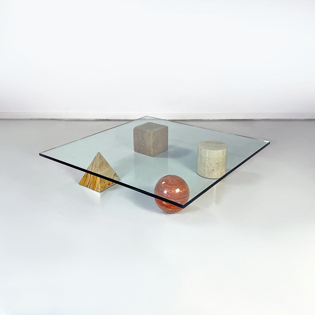 Italian modern crystal and different marble coffee table by Massimo and Lella Vignelli for Casigliani, 1980s.
Metafora model coffee table, with 2 cm thick square glass top, with four geometric shapes in marble to act as table legs: sphere, pyramid,