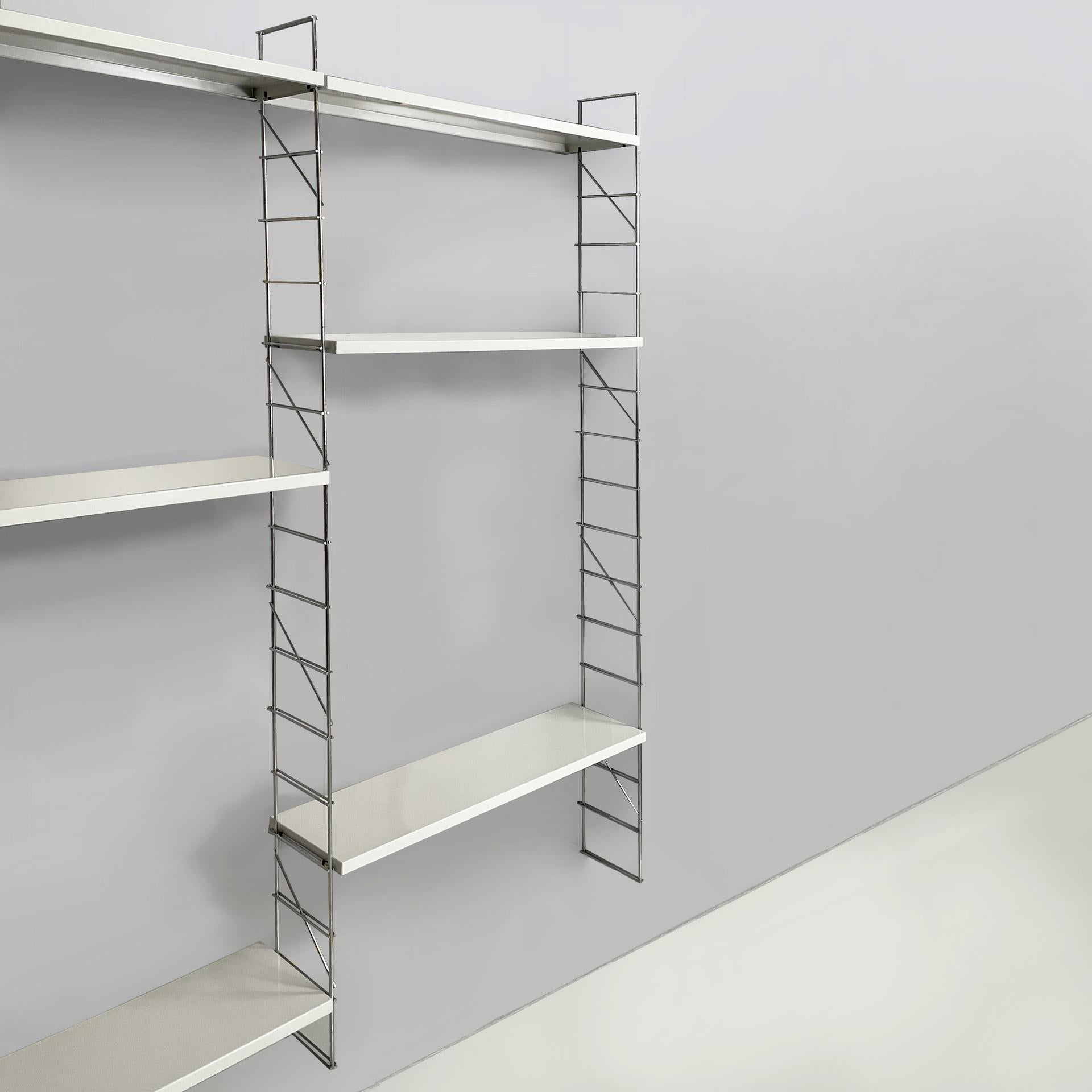 Libreria a parete modulare moderna italiana in metallo bianco e acciaio, anni '80
Libreria da parete modulare in stile String, con nove scaffali rettangolari in metallo verniciato bianco. La struttura è composta da barre d'acciaio verticali,