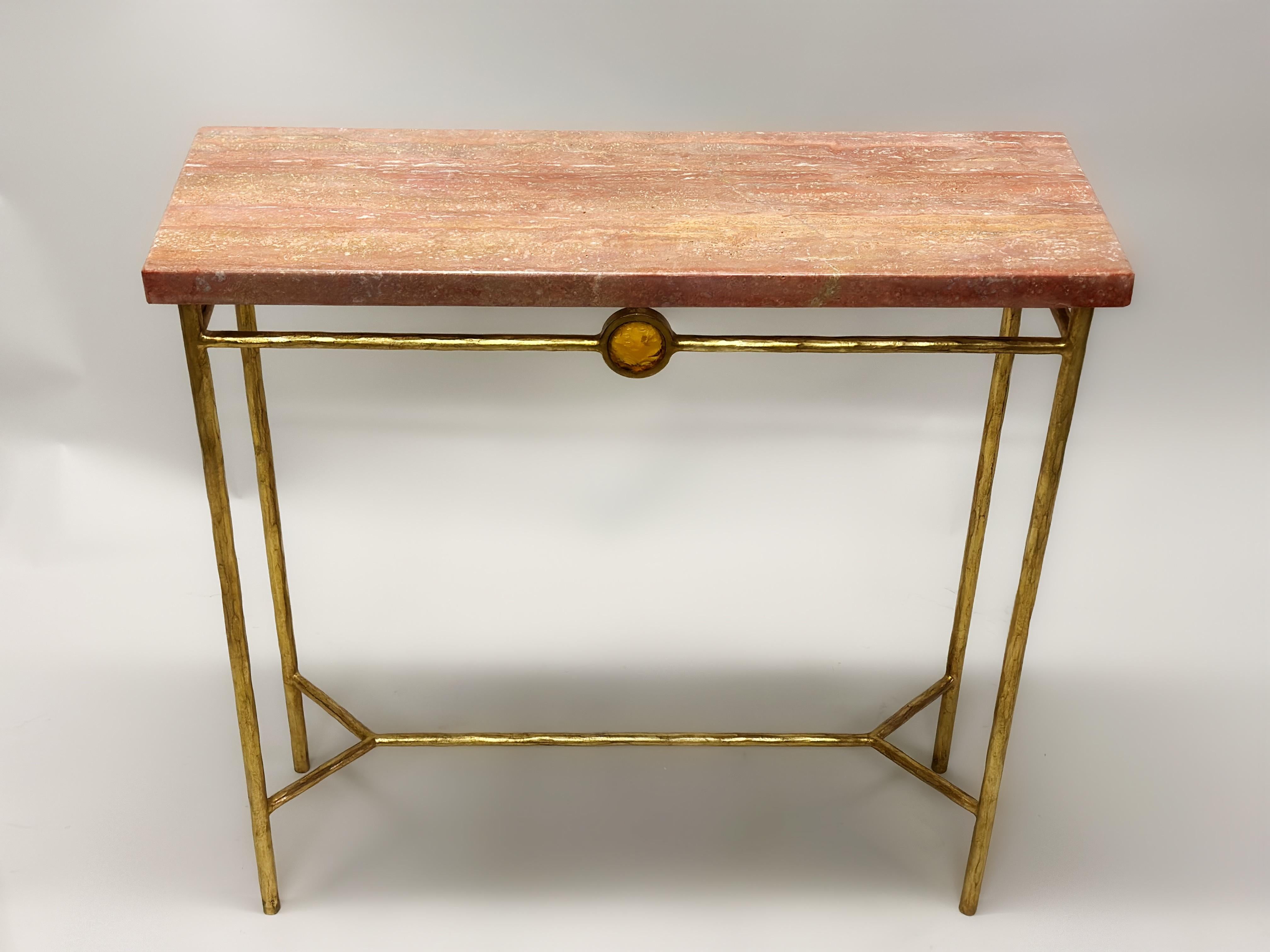 2 Consoles néoclassiques italiennes du milieu du siècle dernier en fer doré avec un médaillon en cristal ambré et des plateaux en travertin persan, par le sculpteur et designer italien Giovanni Banci. Banci a été un designer important pour les