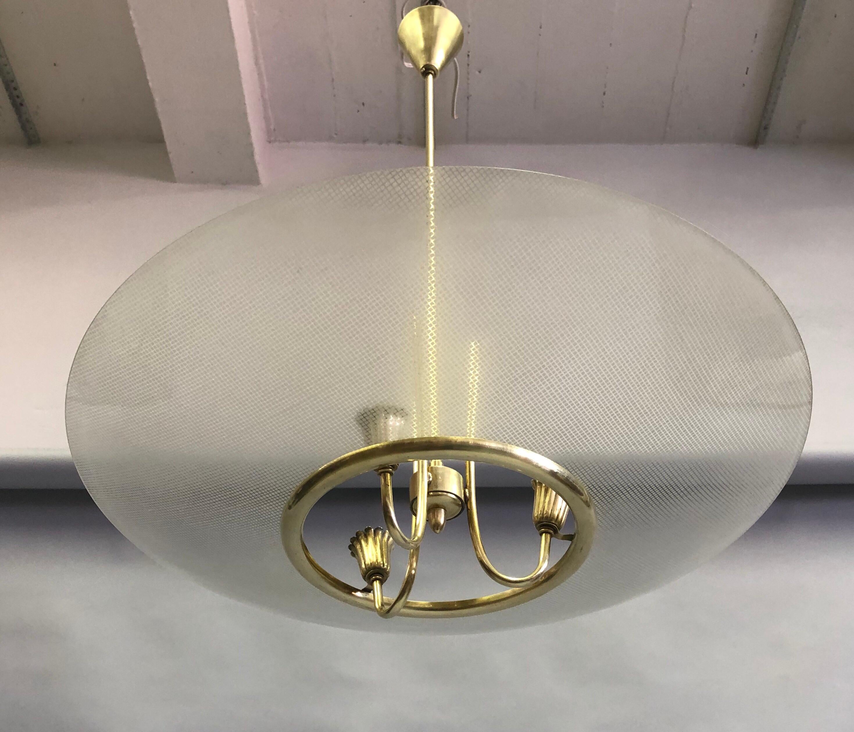 Elegant, timeless Italian Mid-Century Modern Neoclassical brass and sanitized glass chandelier / pendant by Pietro Chiesa for Fontana Arte, circa 1935-1940.

The piece features a unique frosted and satin glass reflector with a round, open circle
