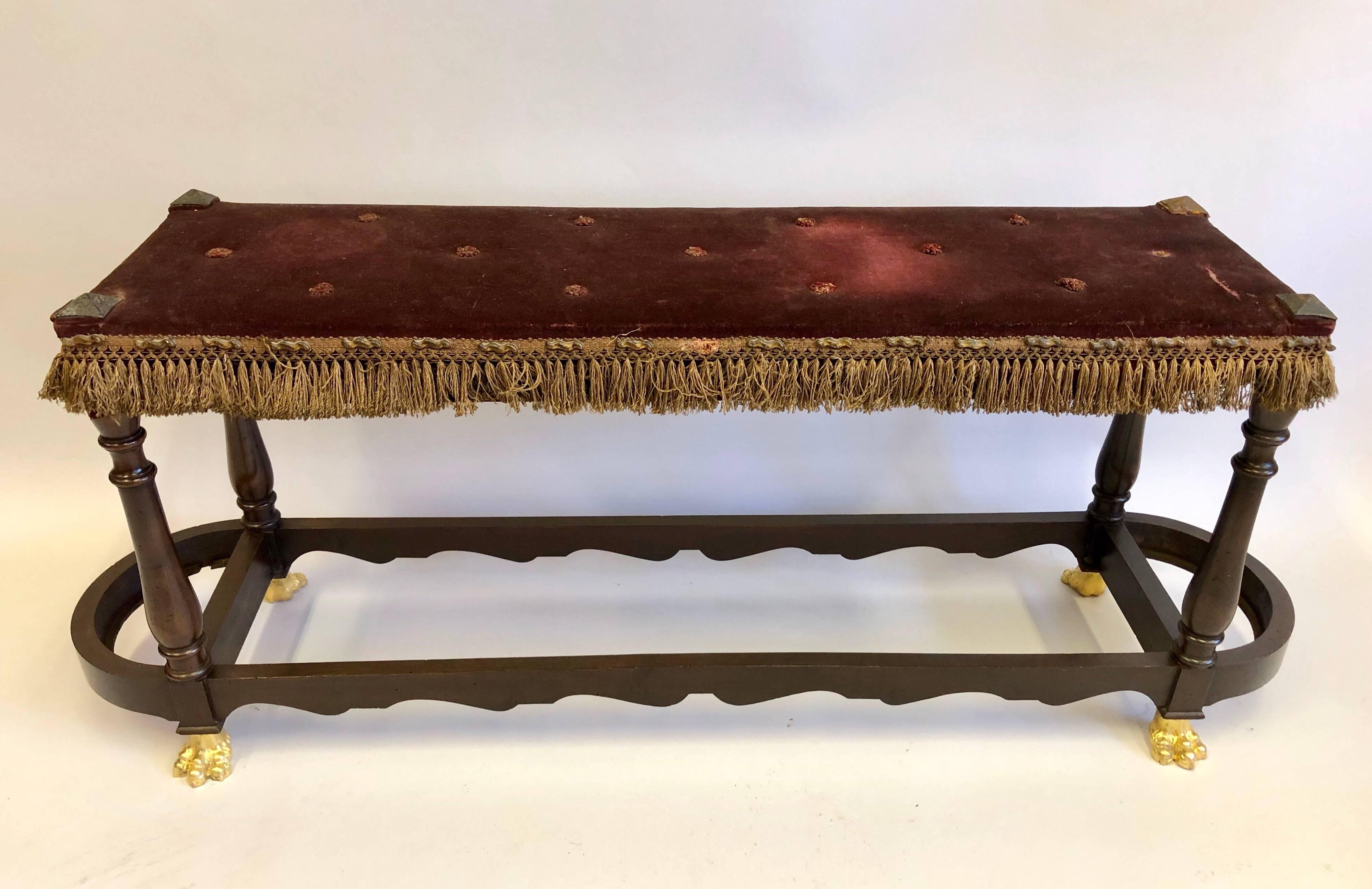 Elegant Italian 19th century neoclassical bench with sober, modern lines, pilaster form legs and gilt bronze lions paw feet. The bench is completed with wrought Iron studs in pyramid form at each corner of the seat.

The bench can fit in a modern