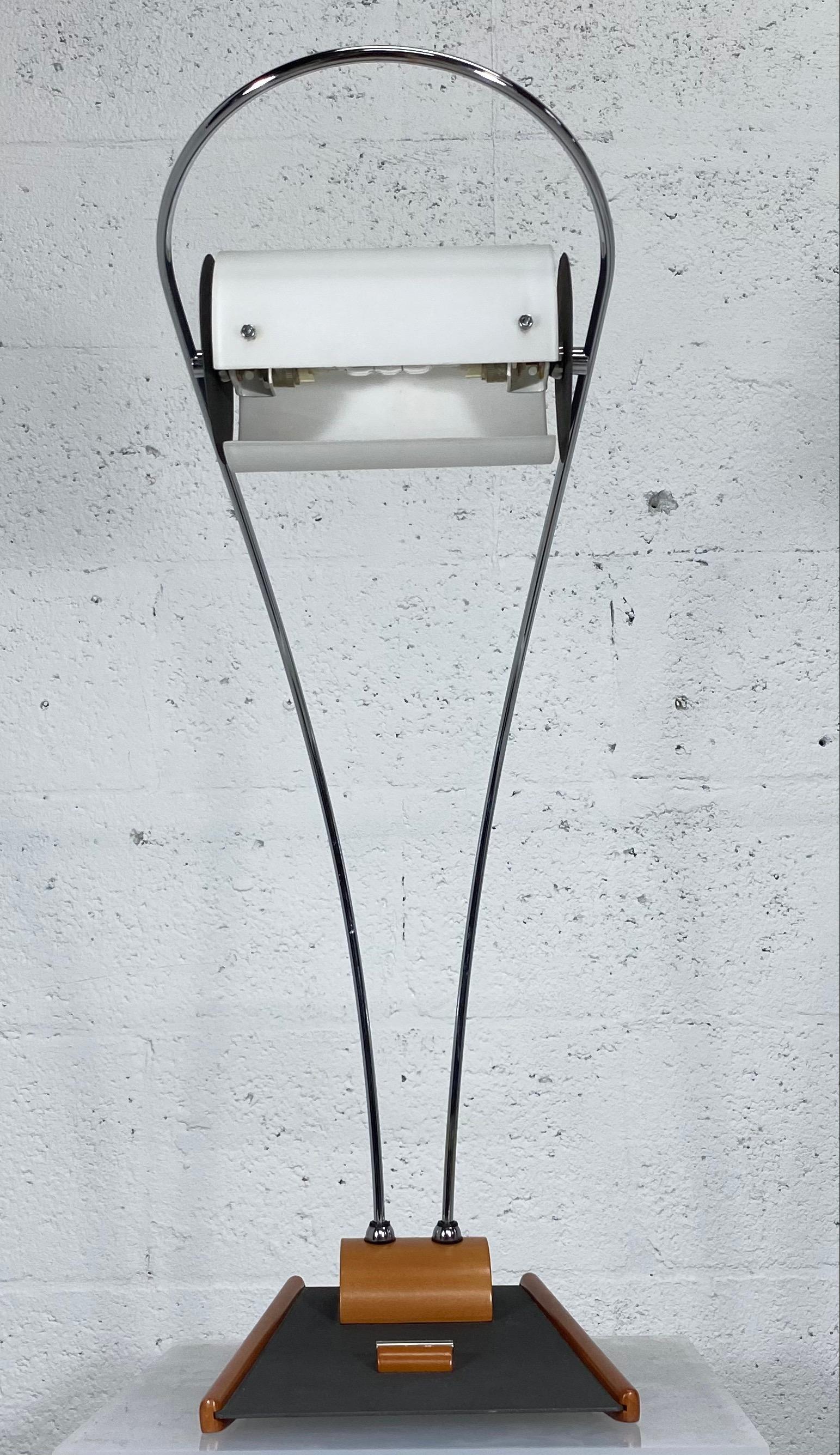 Contemporary Italian modern halogen desk or table lamp with frosted white tubular shade that is supported by a single chrome polished bent metal wire. The base is made of wood and steel. Italy 1999.