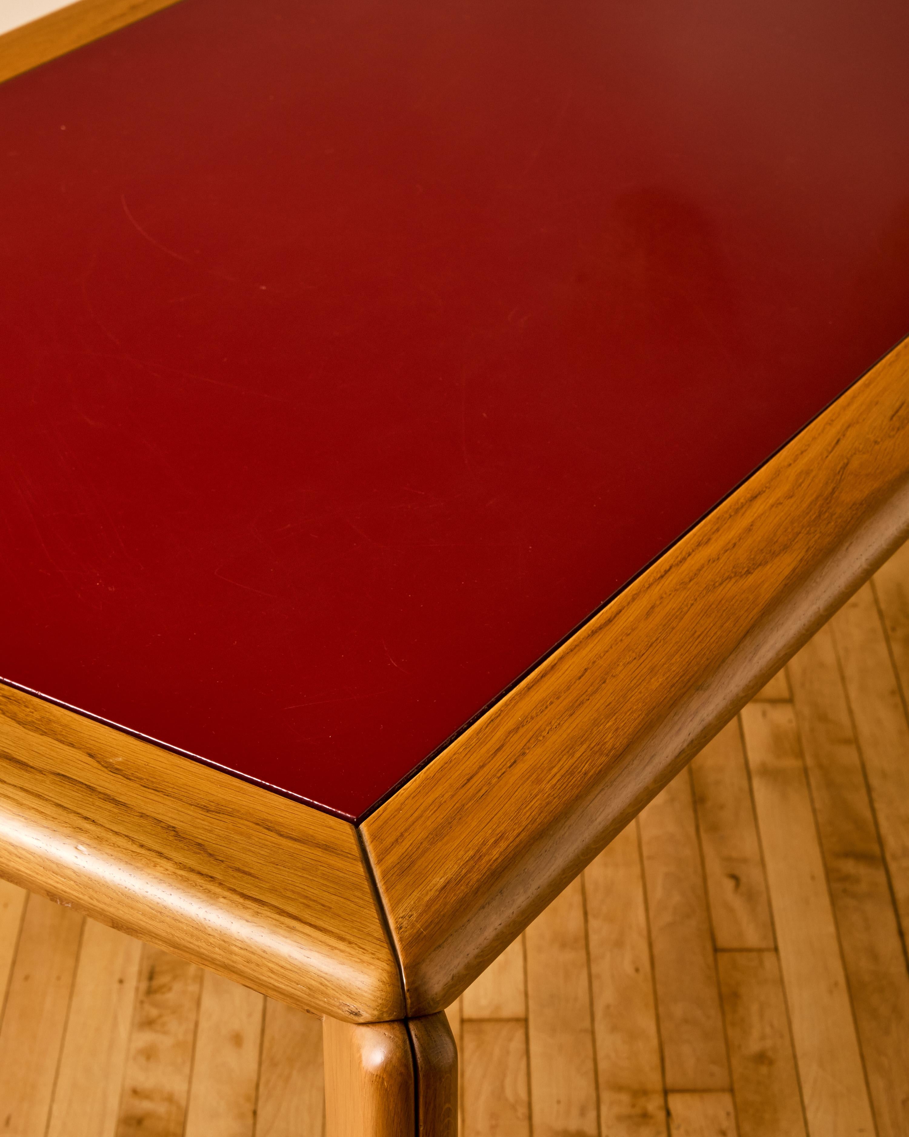 Italian modern oak and red enameled dining table with a dismantling base designed by Hans Von Klier for Rossi di Albizzate. 