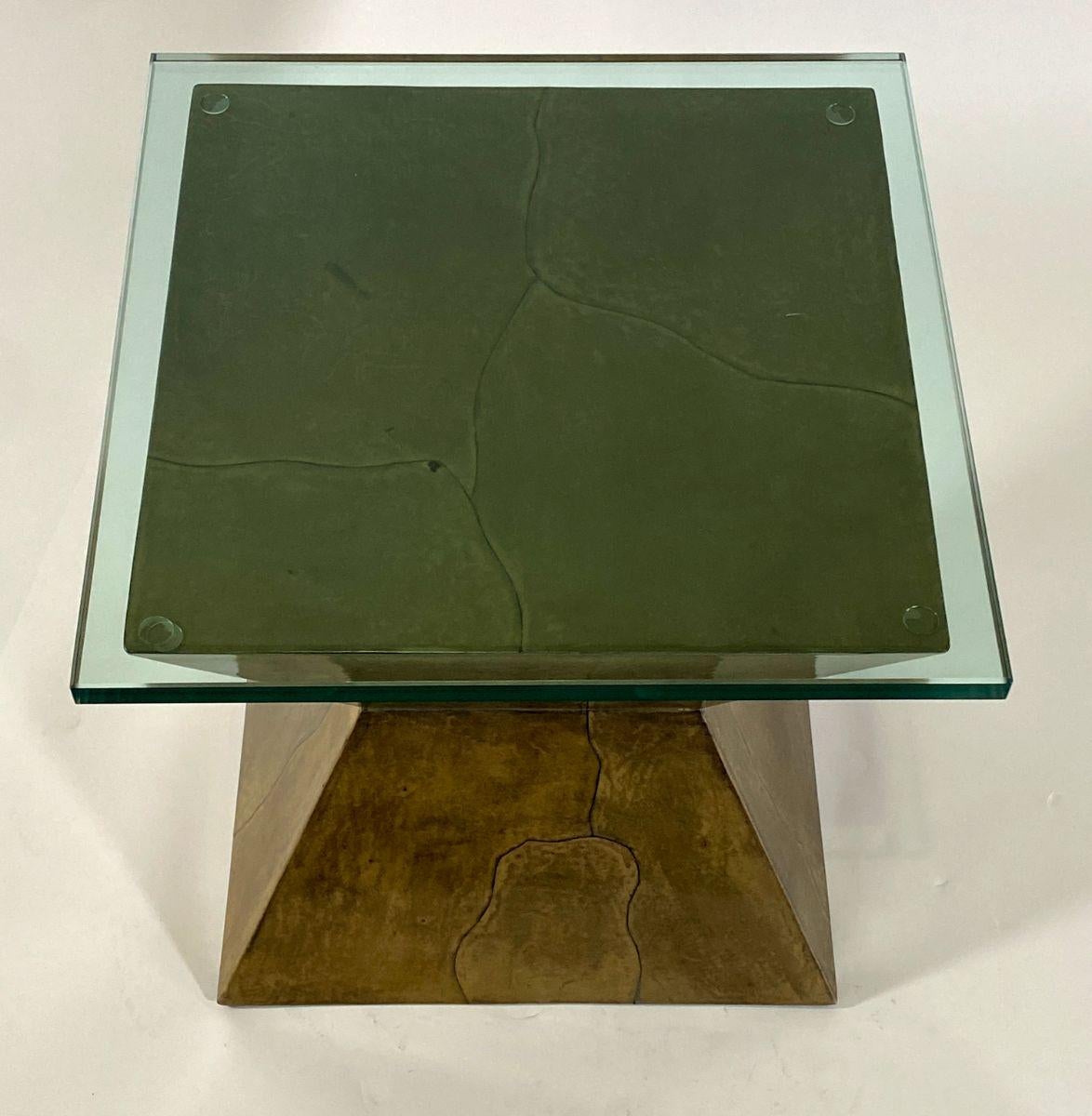 The square top with later glass top above, over an olive goatskin body with trapezoidal shape.