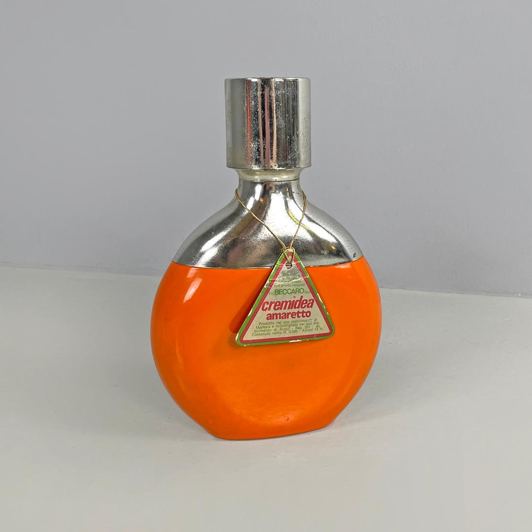 Italian modern orange and silver bottle Cremidea Amaretto by F.lli Beccaro 1970s
Bottle of Cremidea Amaretto with an oval base. The main structure is in orange painted glass, the upper part consisting of the neck and cap are in silver plastic. There