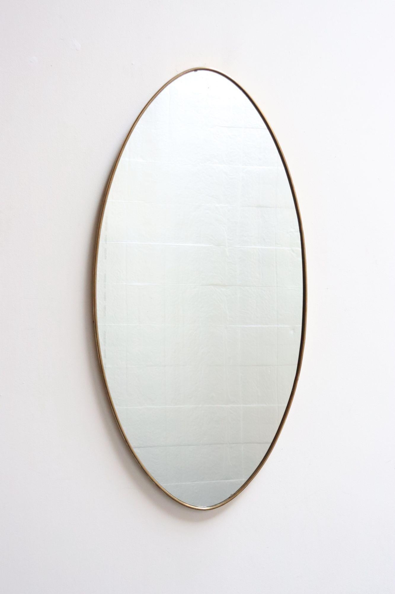 Miroir mural ovale moderne italien d'après Gio Ponti, composé de verre inséré dans un cadre en laiton (vers les années 1960, Italie).
Peut être monté verticalement ou horizontalement (supports présents au verso pour les deux orientations).
Dans