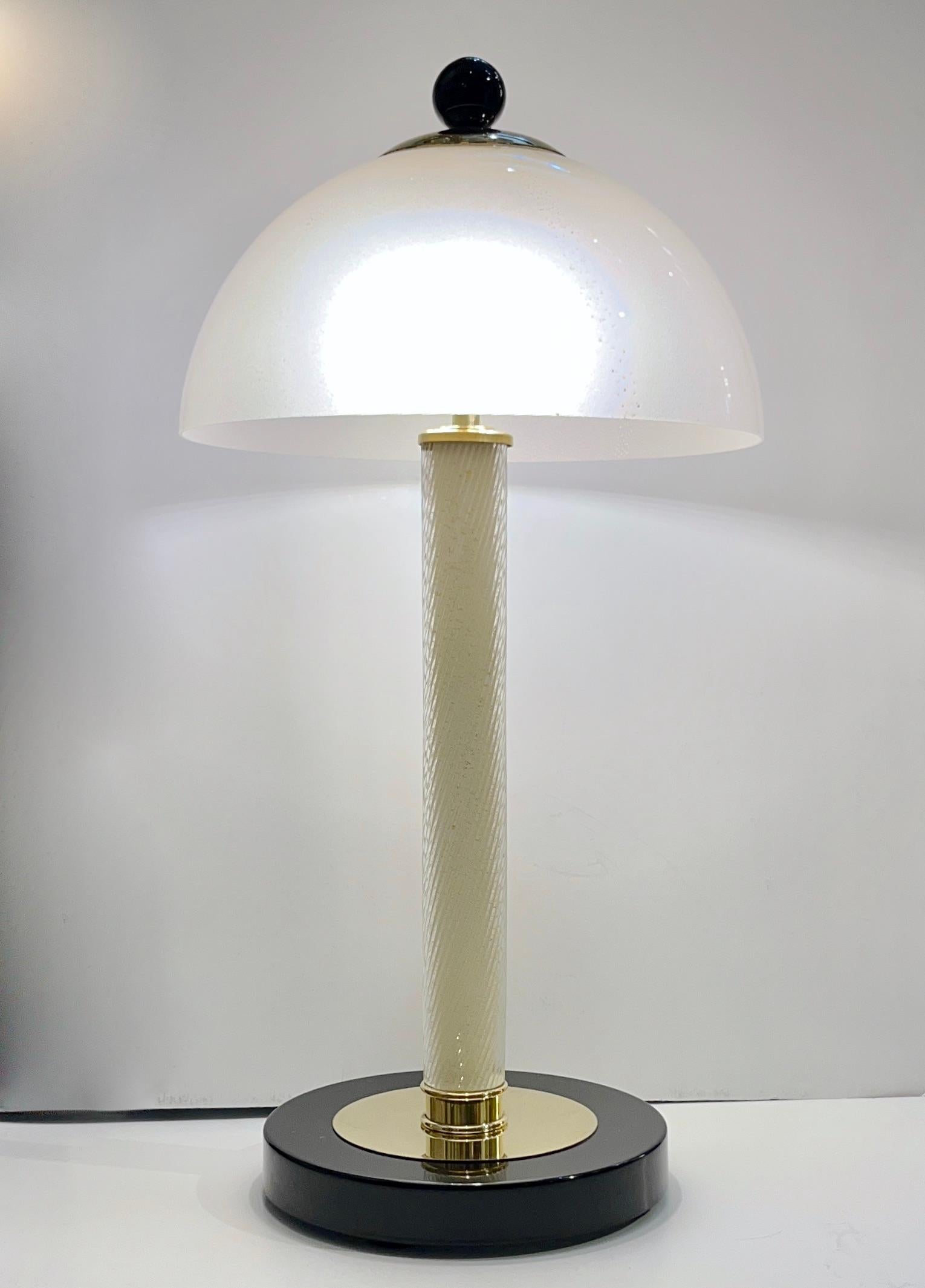 A sophisticated yet minimalist elegant design! This pair of lamps, entirely handcrafted in Italy, with hovering Murano glass domes as top shades, shows high quality of craftsmanship, and great attention to detail: the cupola is made in ivory white