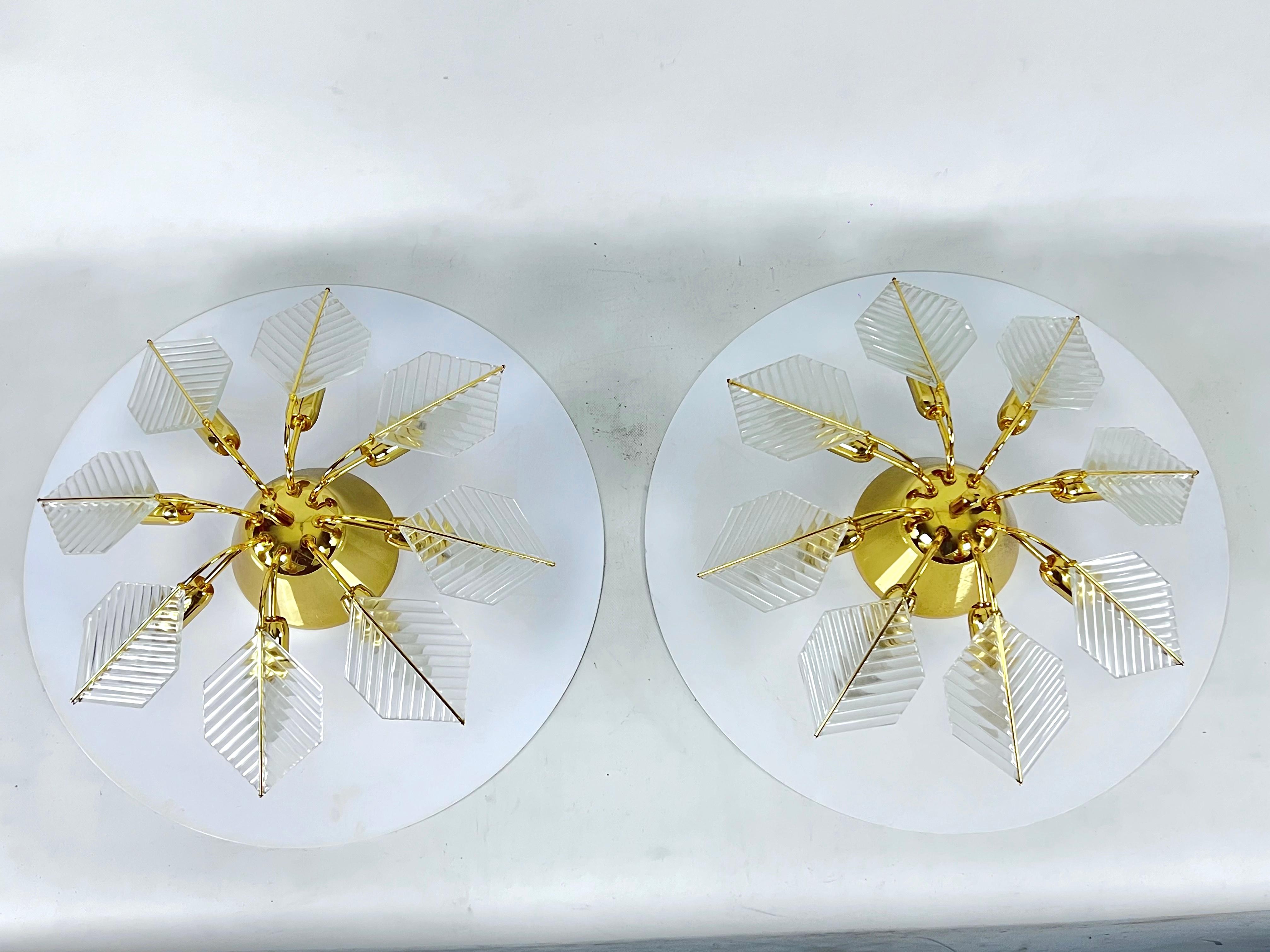 Excellent condition with normal trace of age and use for this set of two brass and glass ceiling lamps produced by Zero Quattro during the late 70s. Measures: diameter of the large white disk 60cm, diameter of the brass fixture 53 cm. Each fixture