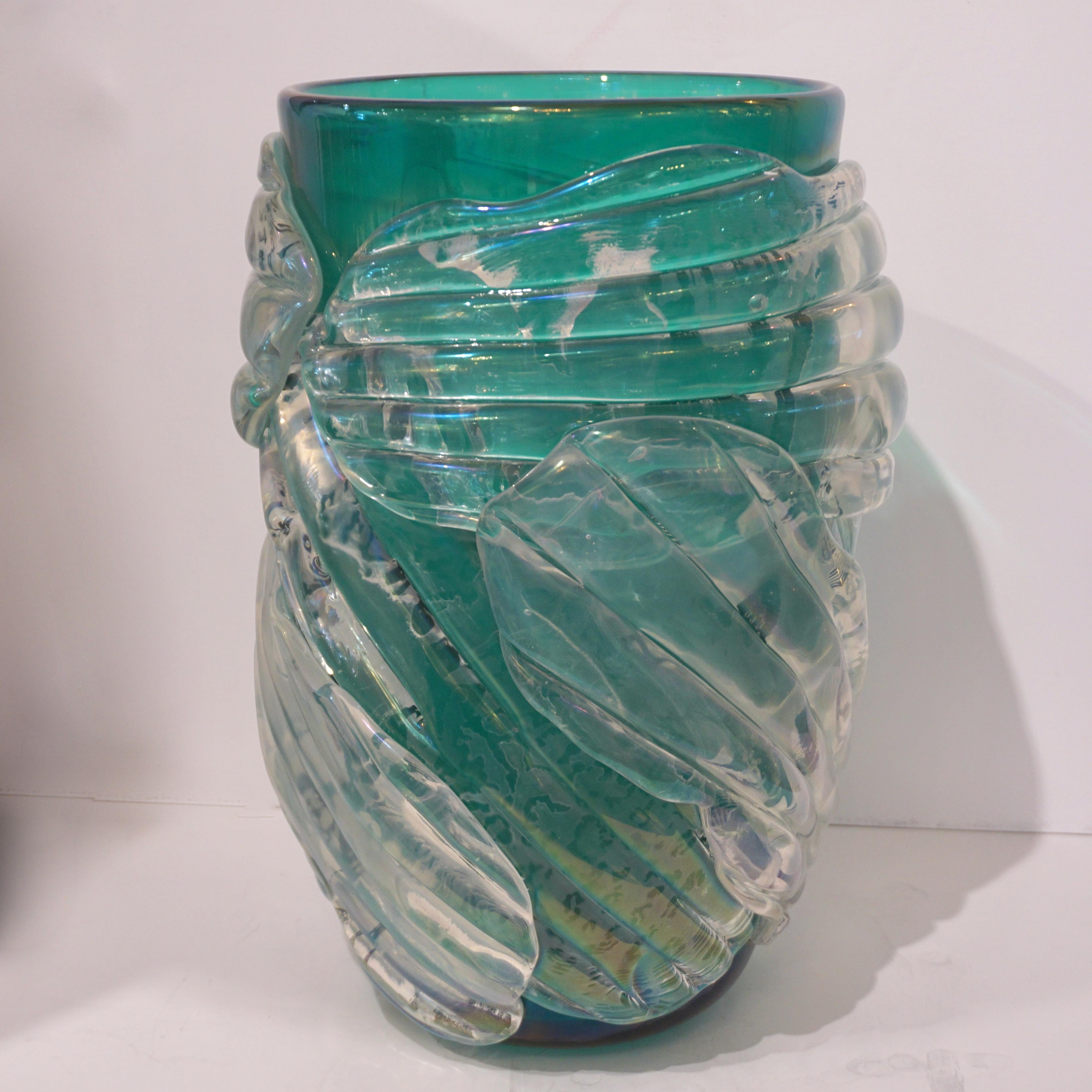 Late 1990s high-quality decorative pair of vases with curated organic design, signed by Cenedese and worked with a sophisticated technique: the bodies in transparent leaf green Murano glass are embraced by overlaid crystal clear Murano glass leaves