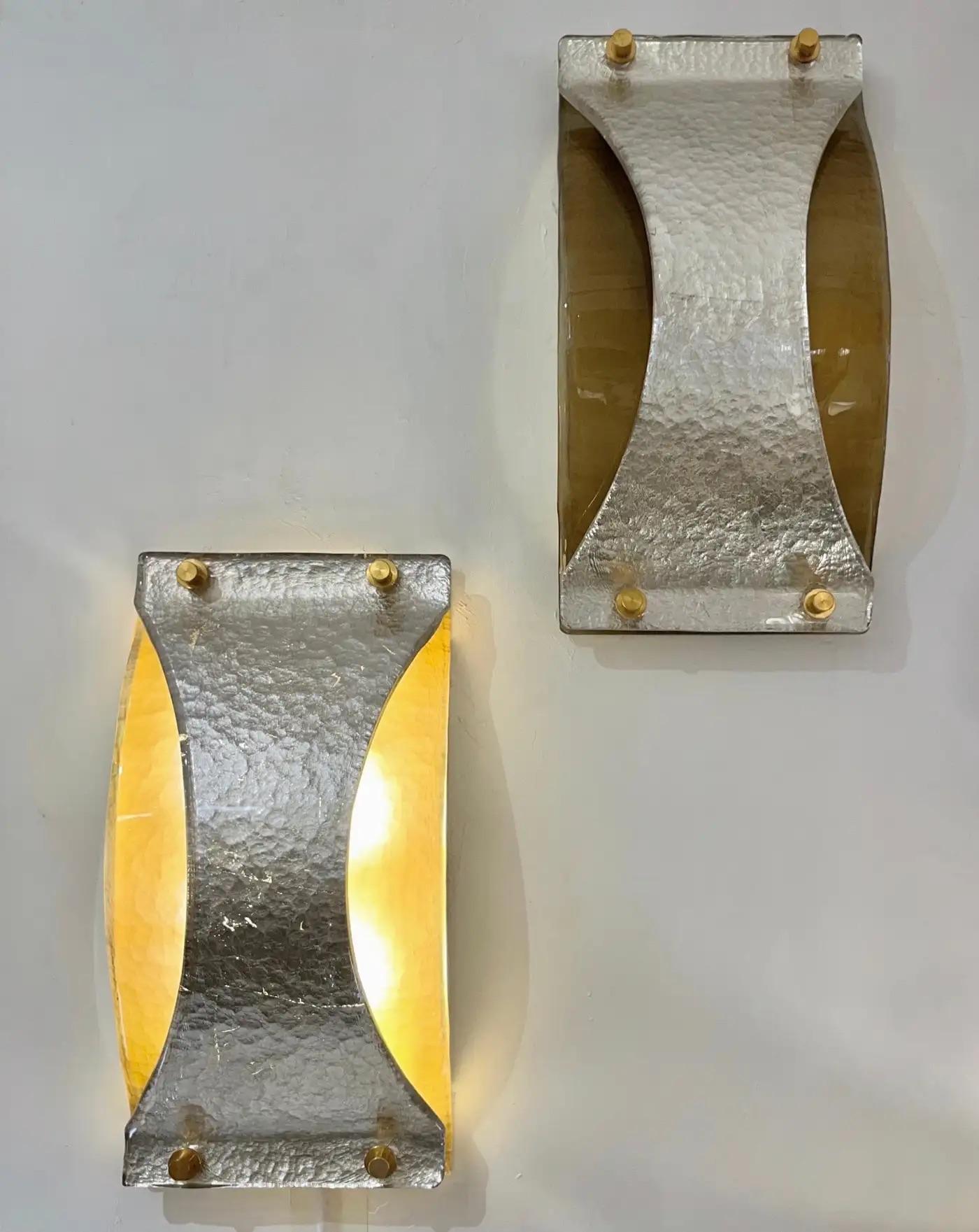 Ein aerodynamisches Design mit einer minimalistischen rechteckigen Form, die durch die Seiten aus Messing verstärkt wird, die eine gewölbte Abdeckung aus geräuchertem Murano-Glas mit einer gehämmerten Textur tragen, die mit einem konkaven X-förmigen