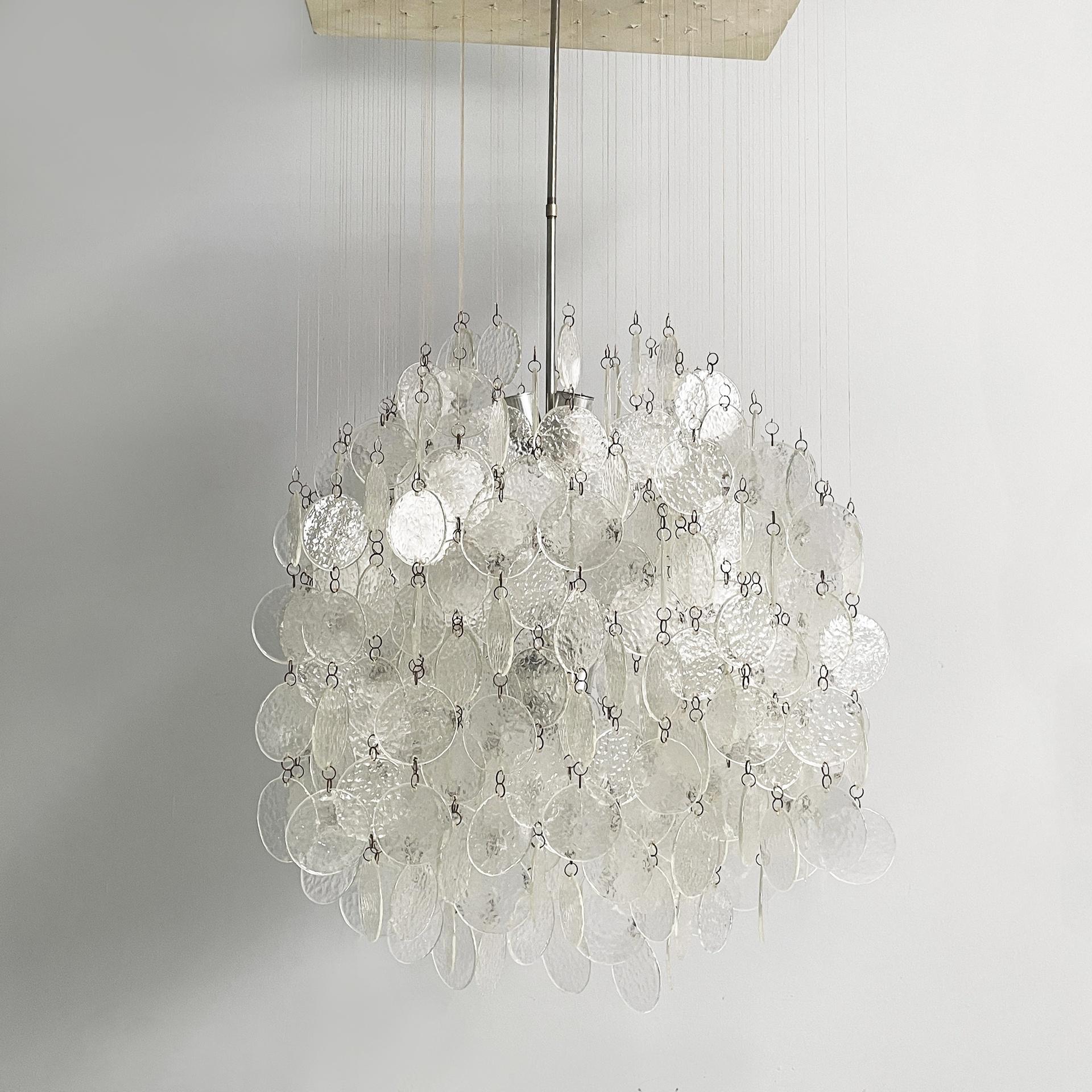 Italian modern pendant chandelier in Murano glass, aluminum and white wood, 1970s
Chandelier or ceiling lamp with diffuser composed of textured Murano glass discs, joined by small metal elements and connected through transparent plastic wires to the