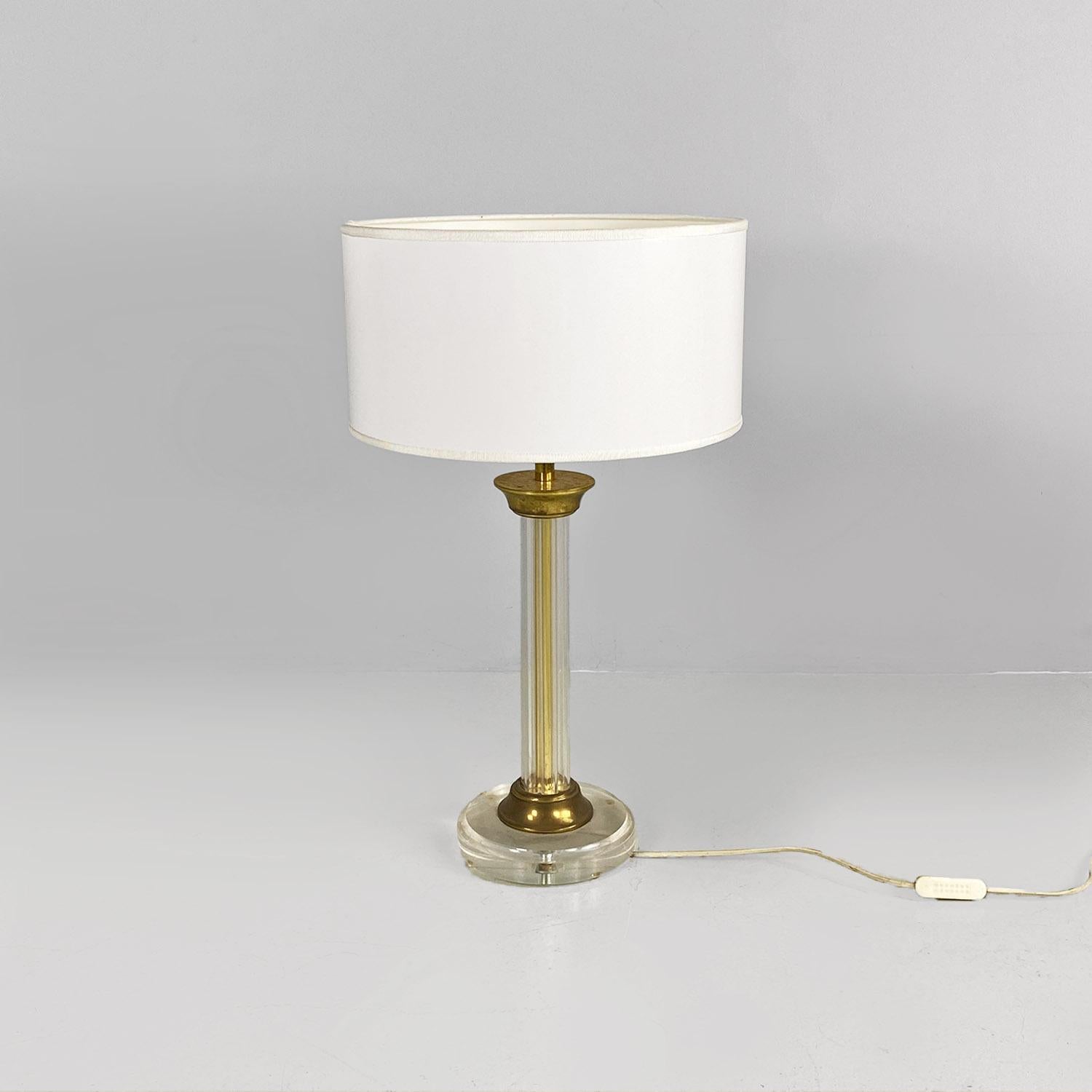 Italian modern plexiglass and brass table lamp with glossy white lampshade, 1970s.
Table lamp with base and stem in transparent plexiglass and with brass details inside and at the ends of the stem. The lampshade was replaced with a new, glossy white
