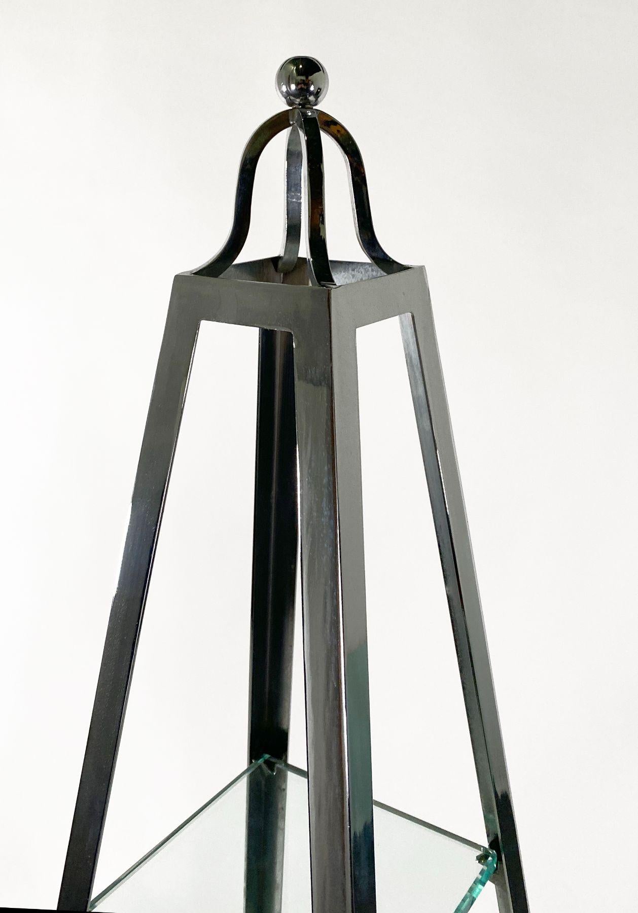 Of typical obelisk form with graduating glass shelves for display starting from a few inches below the top point, to the base.