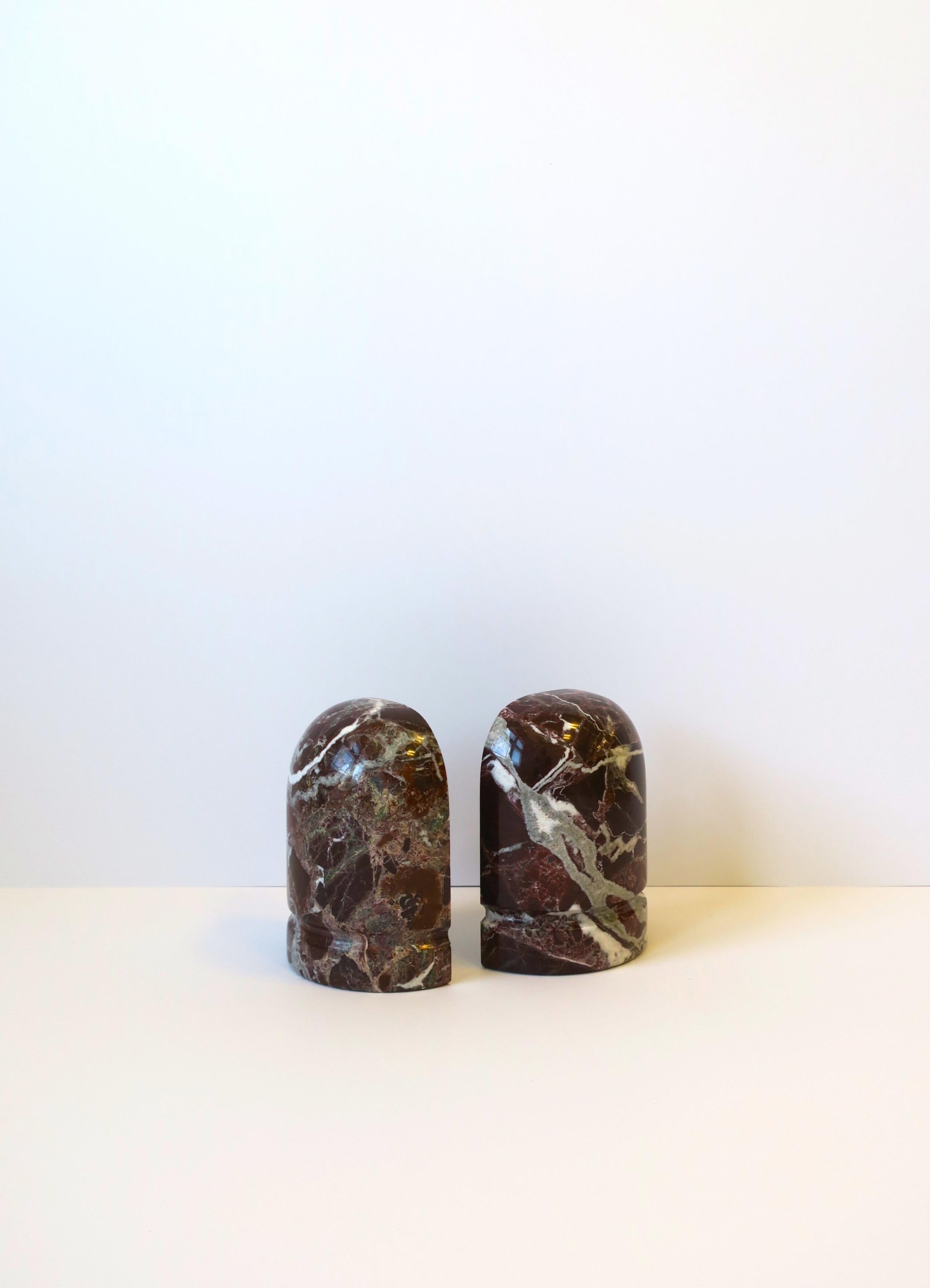 A beautiful and substantial pair of Italian burgundy red marble bookends in the Modern style or Postmodern period, circa late-20th century, 1970s, Italy. Pair are a red burgundy with grey and white veining as shown in images. Dimensions: 6