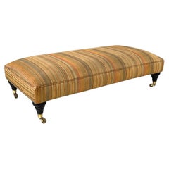 Vintage Italian modern pouf on brass wheels with orange and brown striped fabric, 1970s
