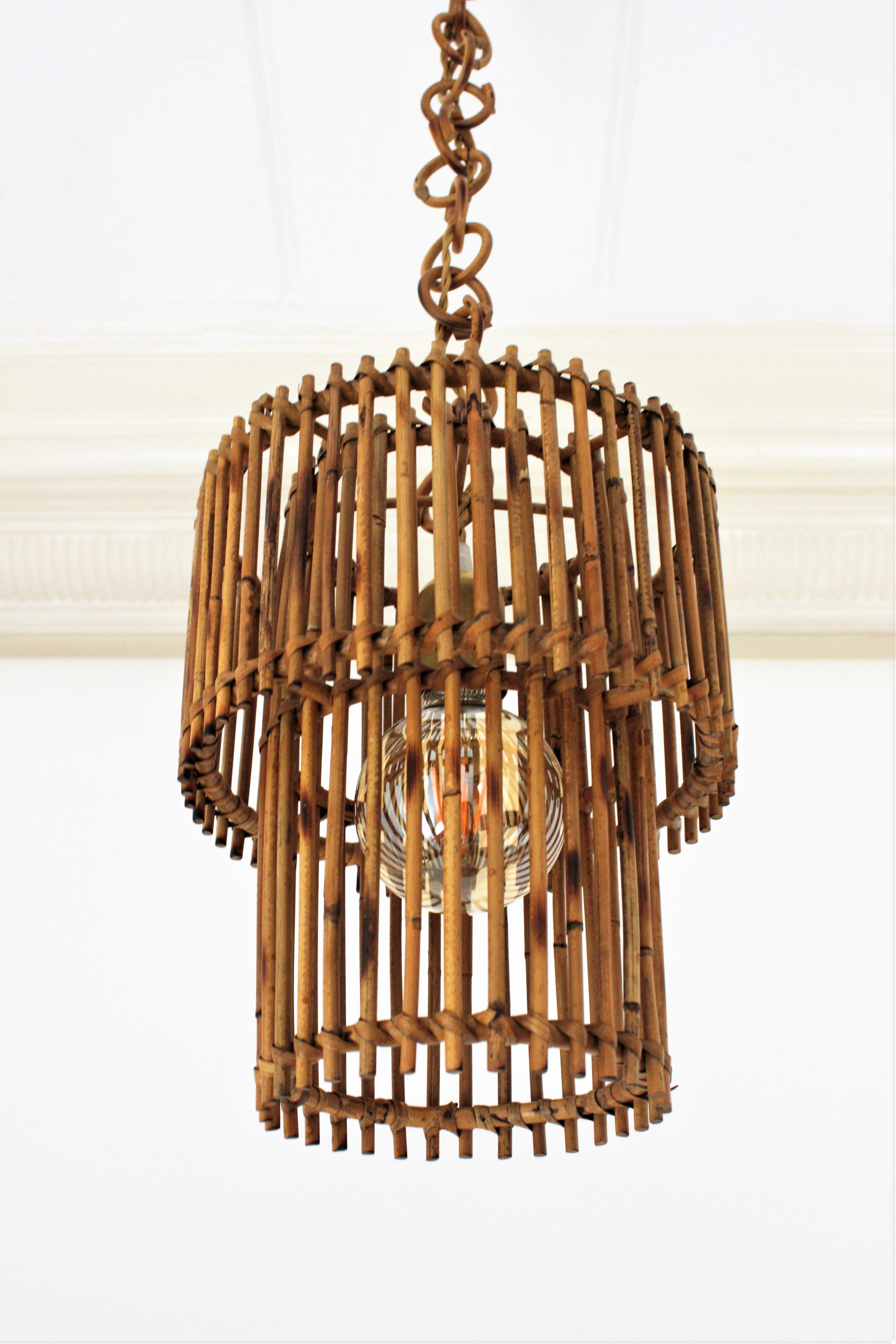 Eye-catching Mid-Century Modern cylinder rattan lantern or pendant ceiling lamp, Italy, 1960s.
This oriental inspired suspension features two concentric cylinders made of rattan or wicker canes. The outer cylindrical shade is 25 cm diameter and the