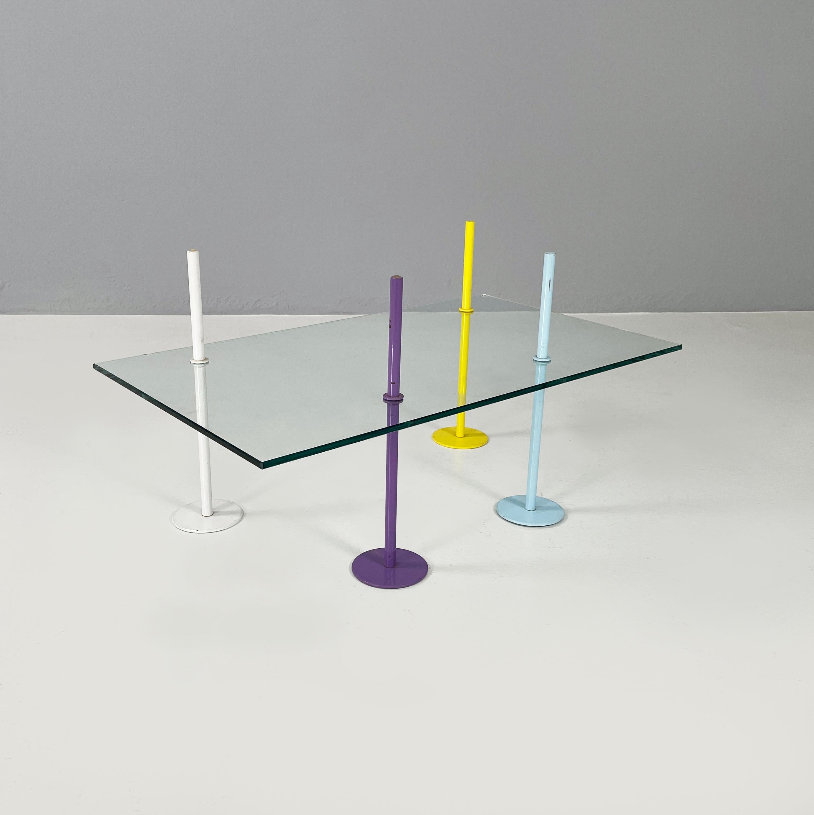 Italian modern Rectangular Coffe table in glass and colored metal rods, 1980s
Coffee table with rectangular glass top. The structure is made up of 4 metal rods that cross the top. Each of them has a different color: purple, yellow, blue and white.