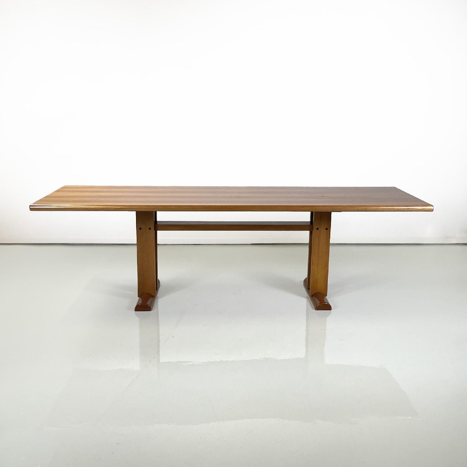 Italian modern rectangular wooden dining table, 1980s
Rectangular dining table made entirely of wood. The top has sides with a semicircular profile, the load-bearing structure is made up of four vertical strips and a crosspiece that joins them with