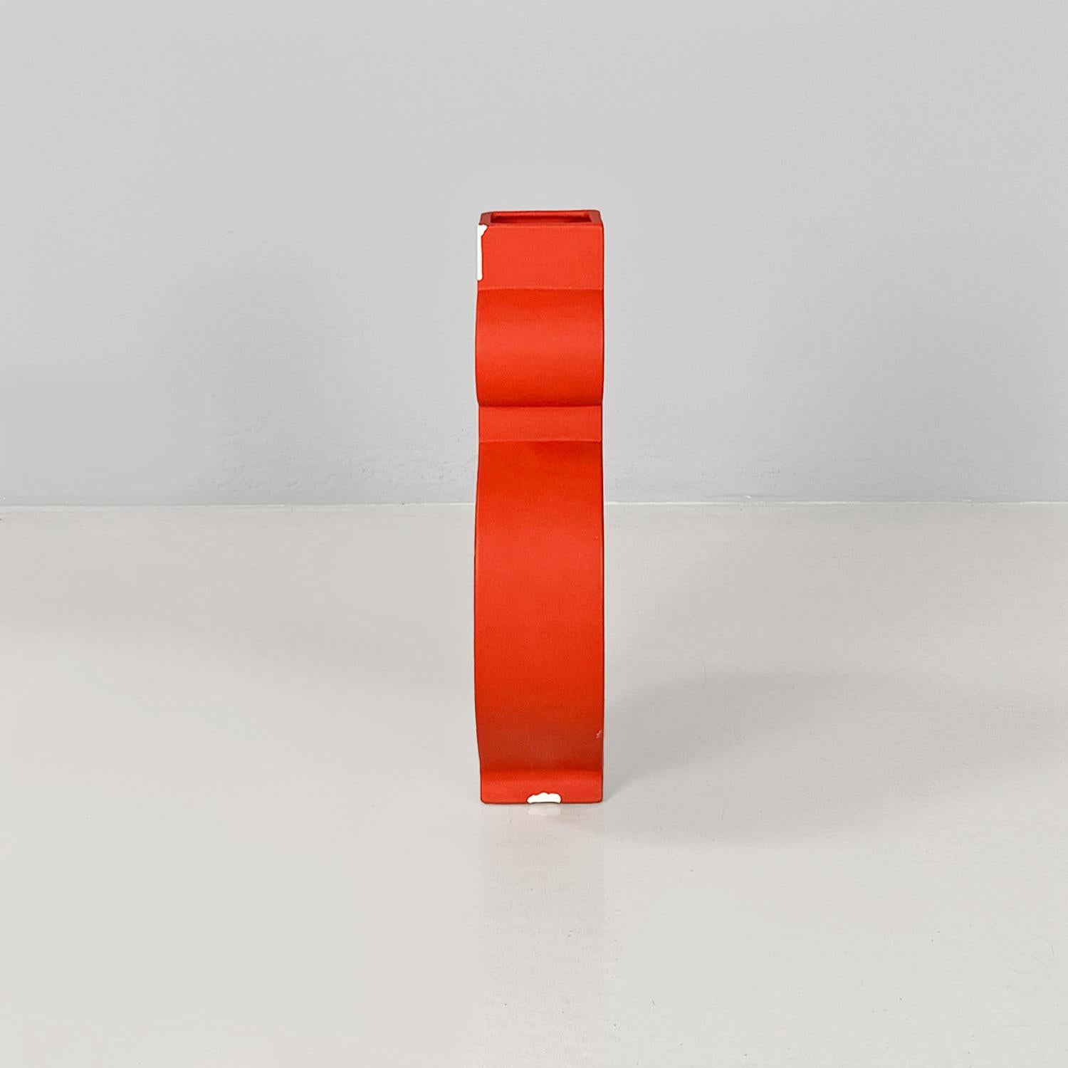 Sculpture entitled Picassa in bright red painted ceramic with a matte finish. The subject of the sculpture is geometric and rounded, with a round hole in the middle. The sculpture can also be used as a vase as it has a square hole in the upper