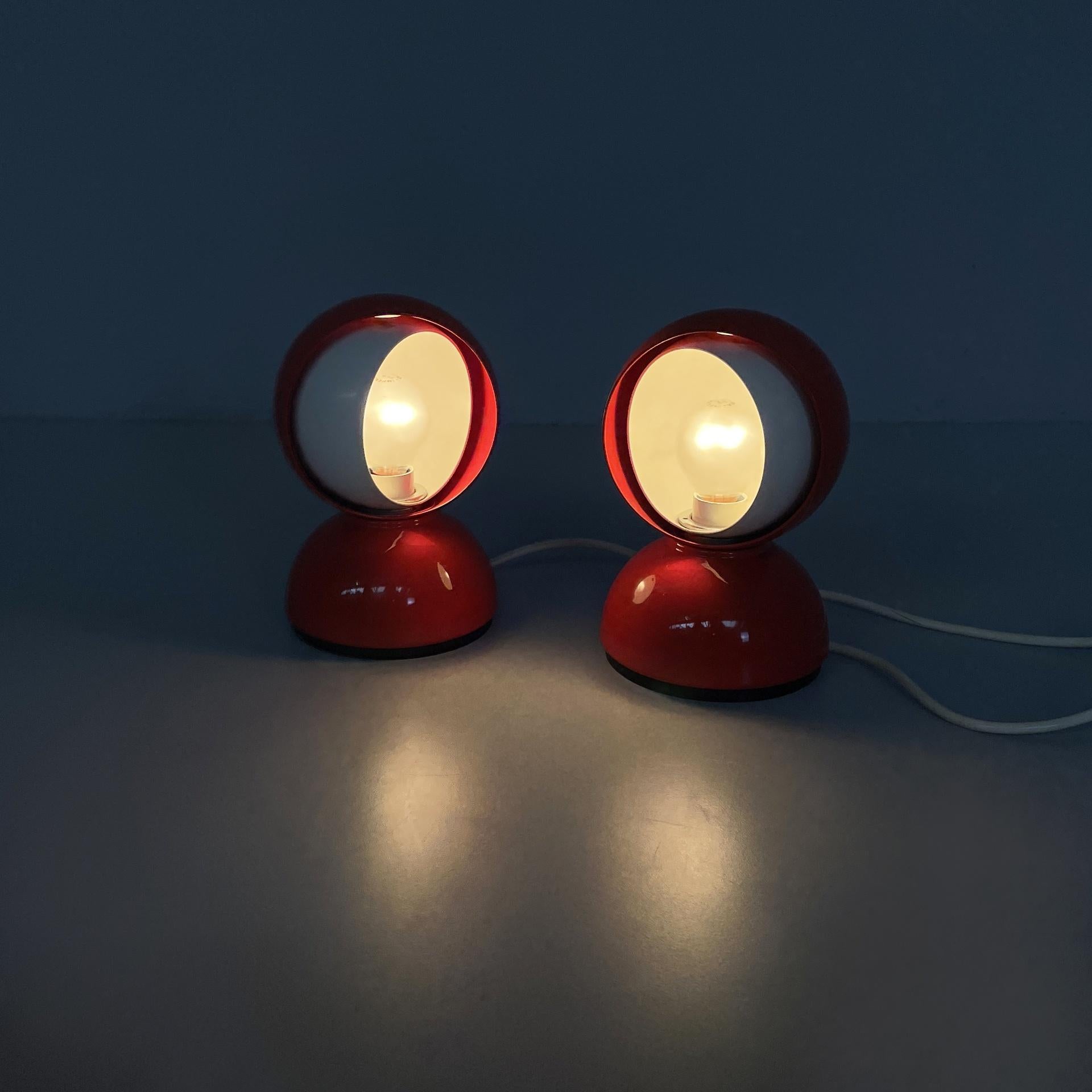 Paar Tischlampen Modell Eclisse mit rundem Sockel. Der kugelförmige Diffusor besteht aus einem Teil aus rotem Metall und einer Halbkugel aus weißem Metall, die gedreht werden kann, um die Lichtquelle zu verbergen. Der runde Sockel ist aus rot