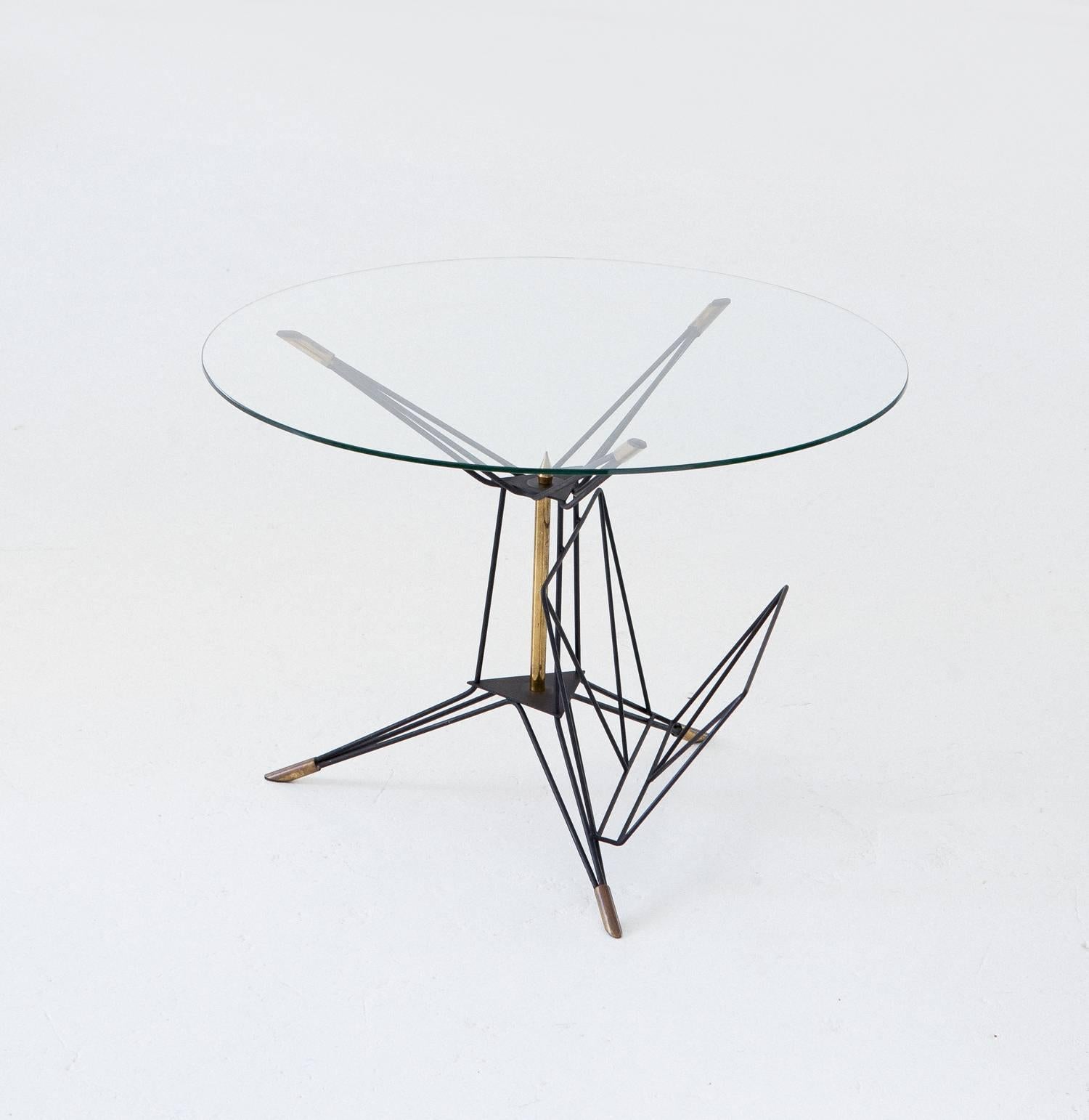 A sculptural and airy Coffee table manufactured in Italy in 1950s
This side table has a geometrical black enameled iron and brass frame with glass top and magazine holder
This is a Mid-Century Modern style object.
The object has not been restored