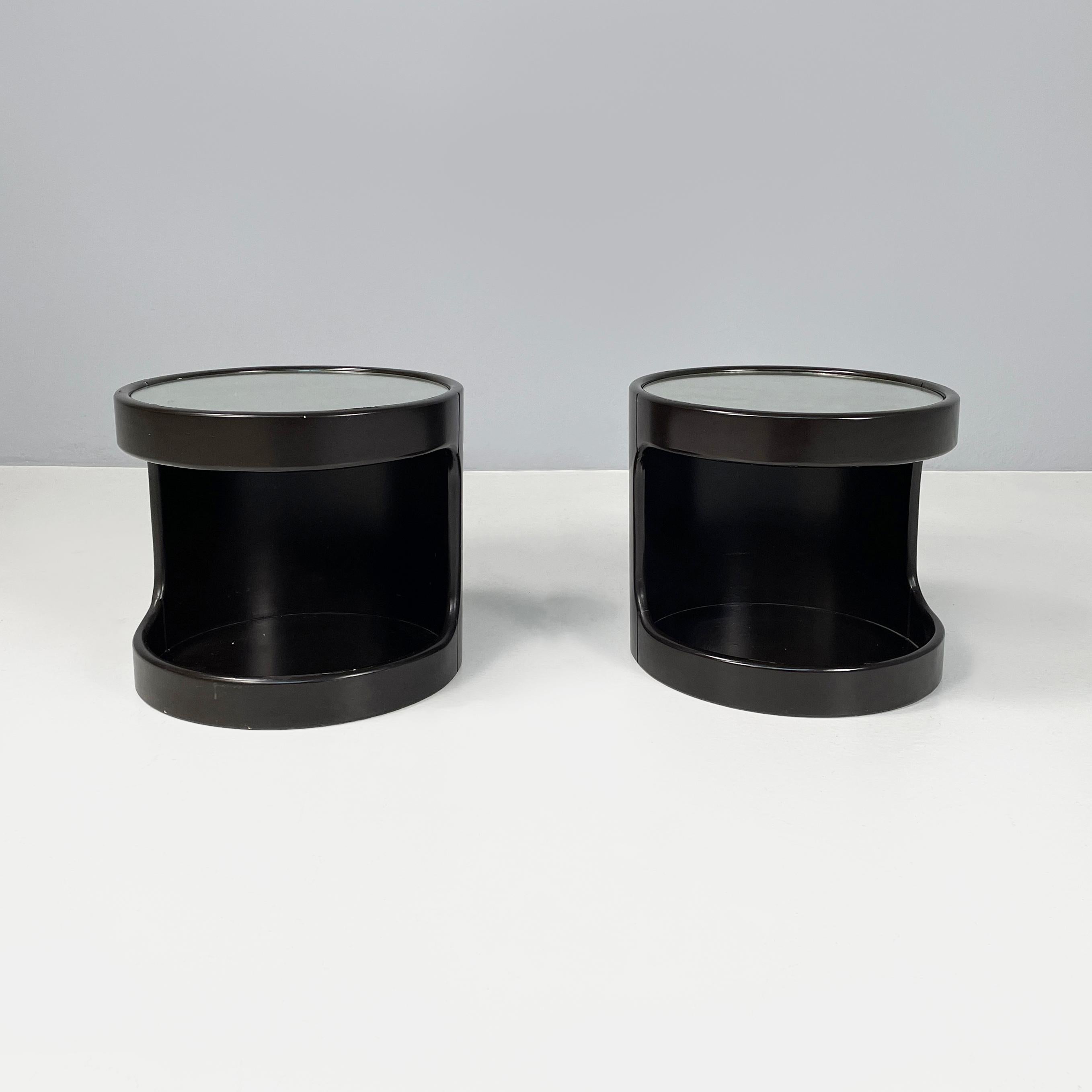 Italian modern Round coffee tables in dark brown wood and mirror, 1980s
Pair of coffee tables with round mirrored top. The cylindrical structure is in dark brown lacquered wood. On the front it has an open compartment. The coffee tables can be used