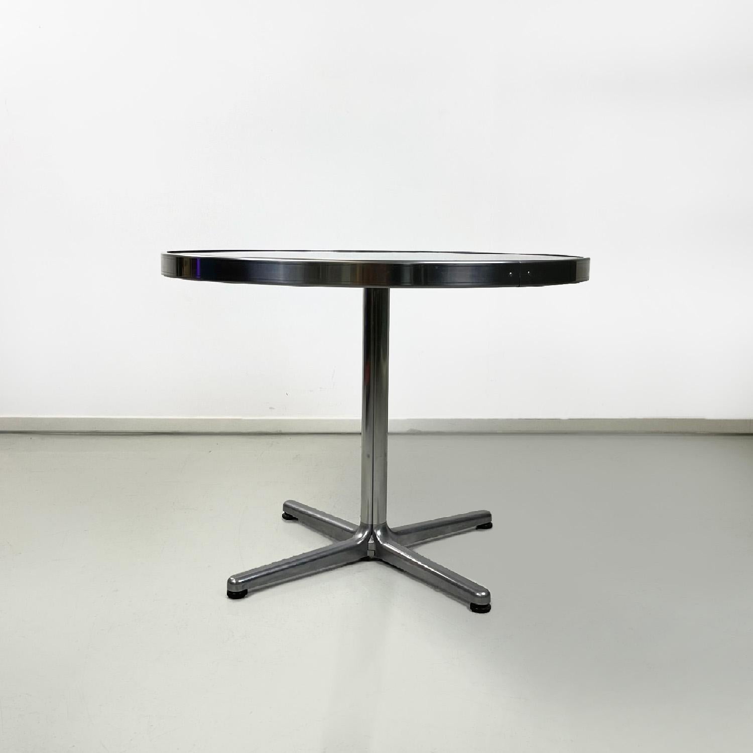Italian modern round steel dining table, 1970s
Dining table with round top, entirely in steel. The top is embraced along its entire circumference by a sheet, also in steel, which folds over the top to create an edge. It has a central leg from which
