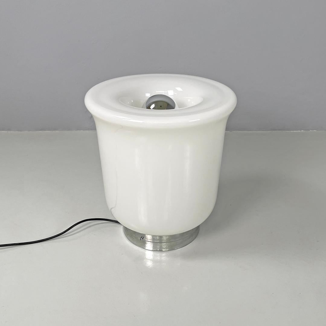 Italian modern round table lamp with curved profiles metal and white glass 1970s
Table lamp with round base. The round lampshade is made of opaline white glass and resembles the shape of a flower as it is narrower at the base and widens towards the