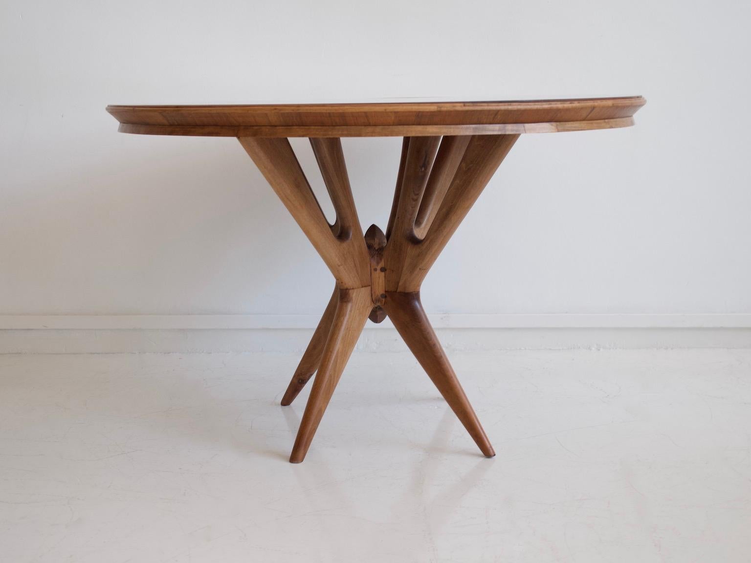 Round dining table made of thick walnut wood with back-painted glass top. Manufactured in Italy in the 1950s. Tiny scratches on the glass, seen on photos.