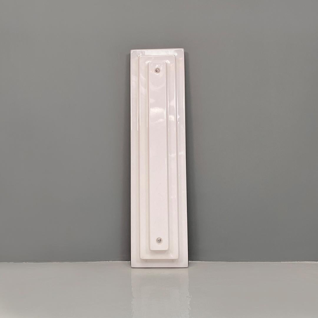 Italian modern rectangular, large, sculptural stepped profile white plexiglass and metal wall lamp, 1970s.
Large, rectangular and sculptural wall lamp with a 