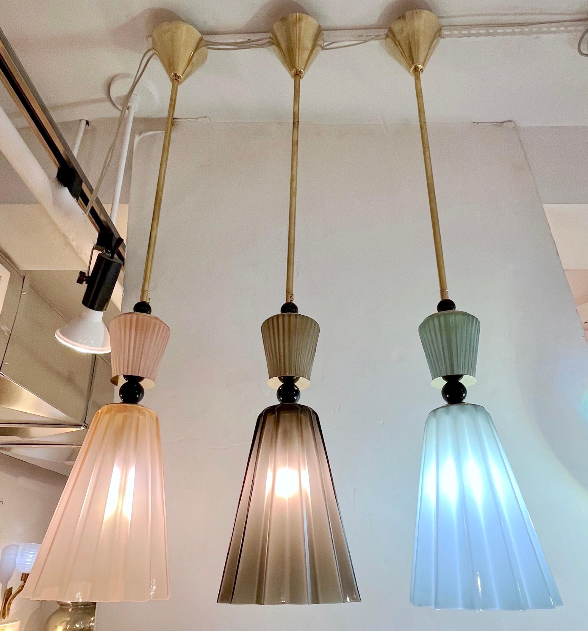 3 Pendants in opaline blown Murano glass of star shape, each a different color in smoked gray, light pink, aqua-blue, decorated with a reeded glass cap accompanied with black glass spheres, fitted with a handmade triangular canopy. High quality of