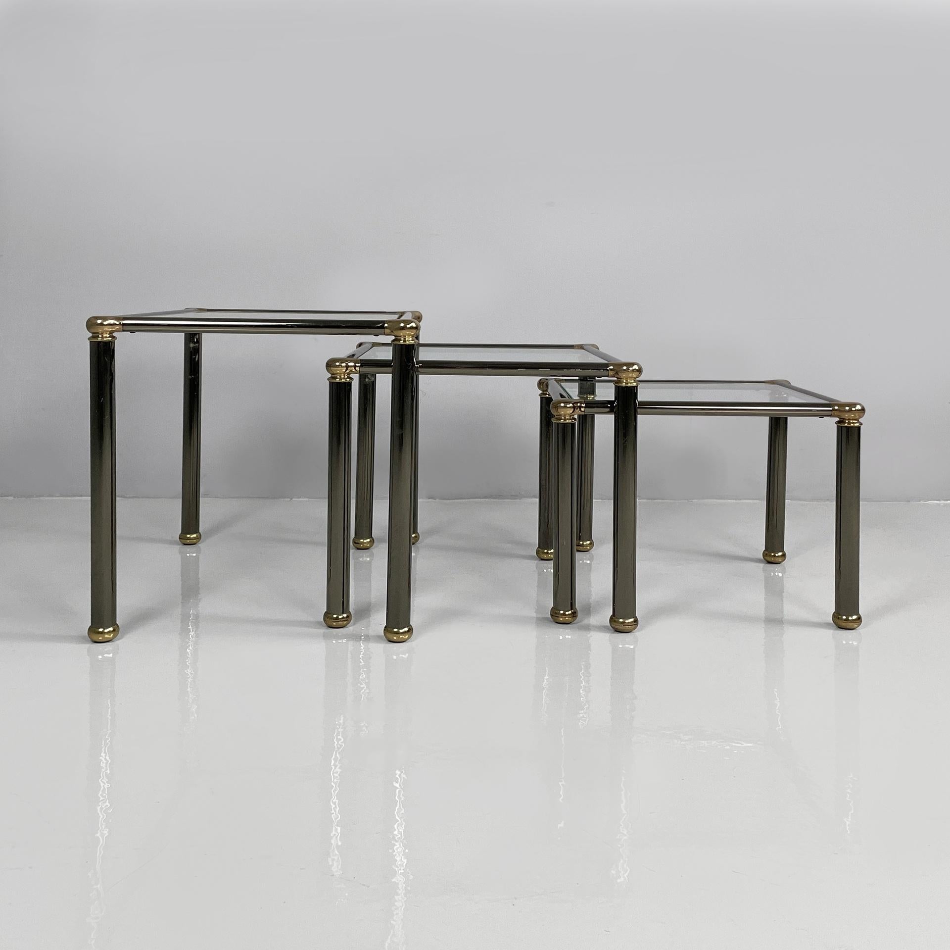 Italian modern set of coffe tables in metal and glass, 1980s
Set of three coffee tables with square glass tops. The structure and legs are made of gray-painted anodized metal tubes with gold-plated metal corners. Spherical gold-plated metal feet.