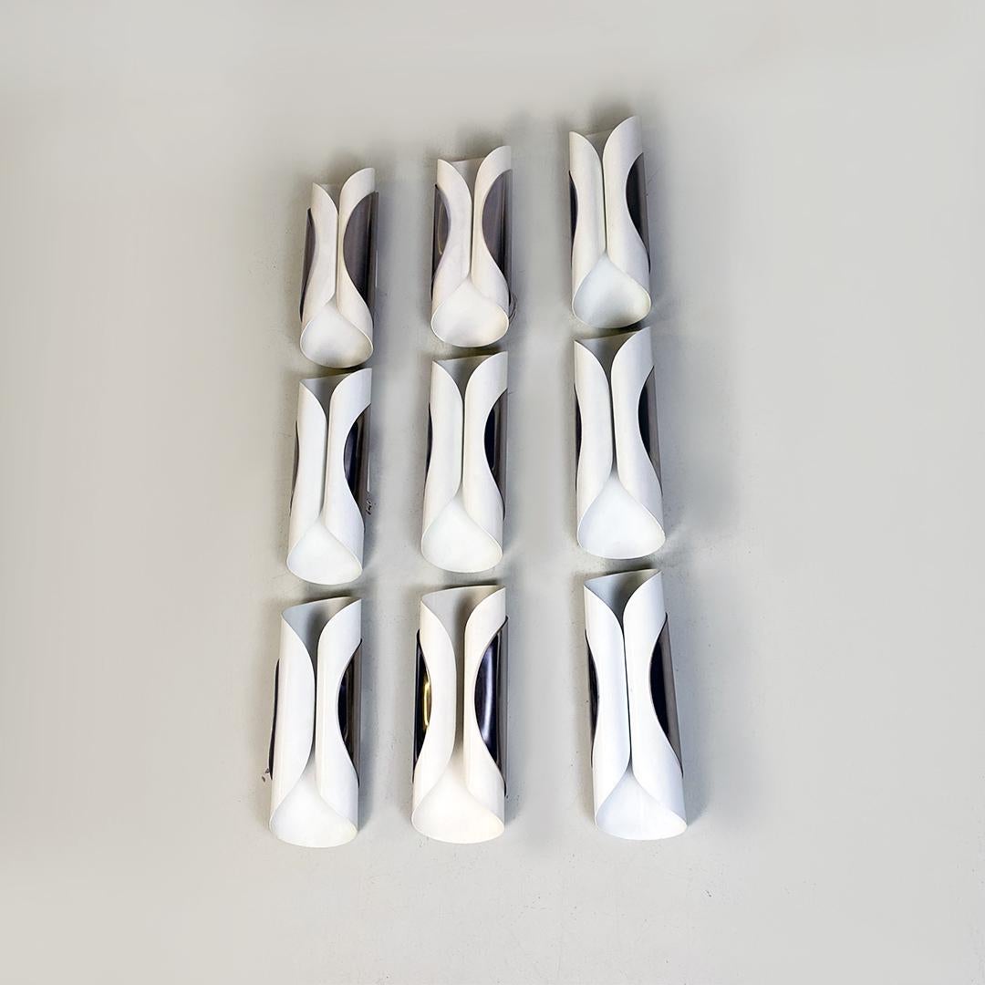 Italian modern set of nine curved metal sheet wall lamps, 1970s.
Set of nine sconces or wall lamps with a structure formed by two curved sheets, a larger internal white sheet wrapped by another smaller sheet with a chrome finish. Each piece