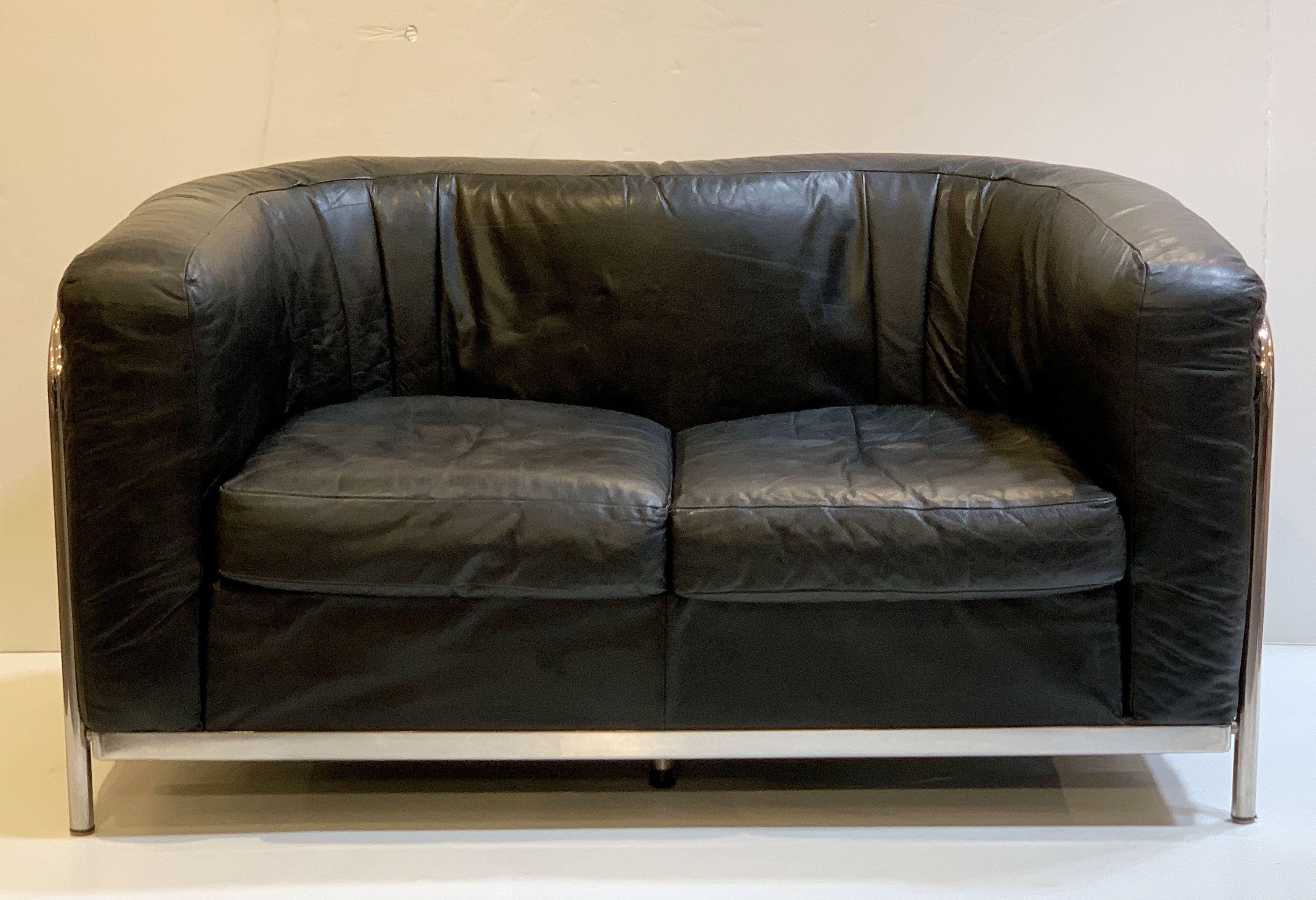 A fine, comfortable Italian sofa in the Modern style, featuring a stylish, bowed tubular chrome body with upholstered cushion back and sides of black leather, two fitted seat cushions of black leather, and resting on chrome feet.

The Zanotta