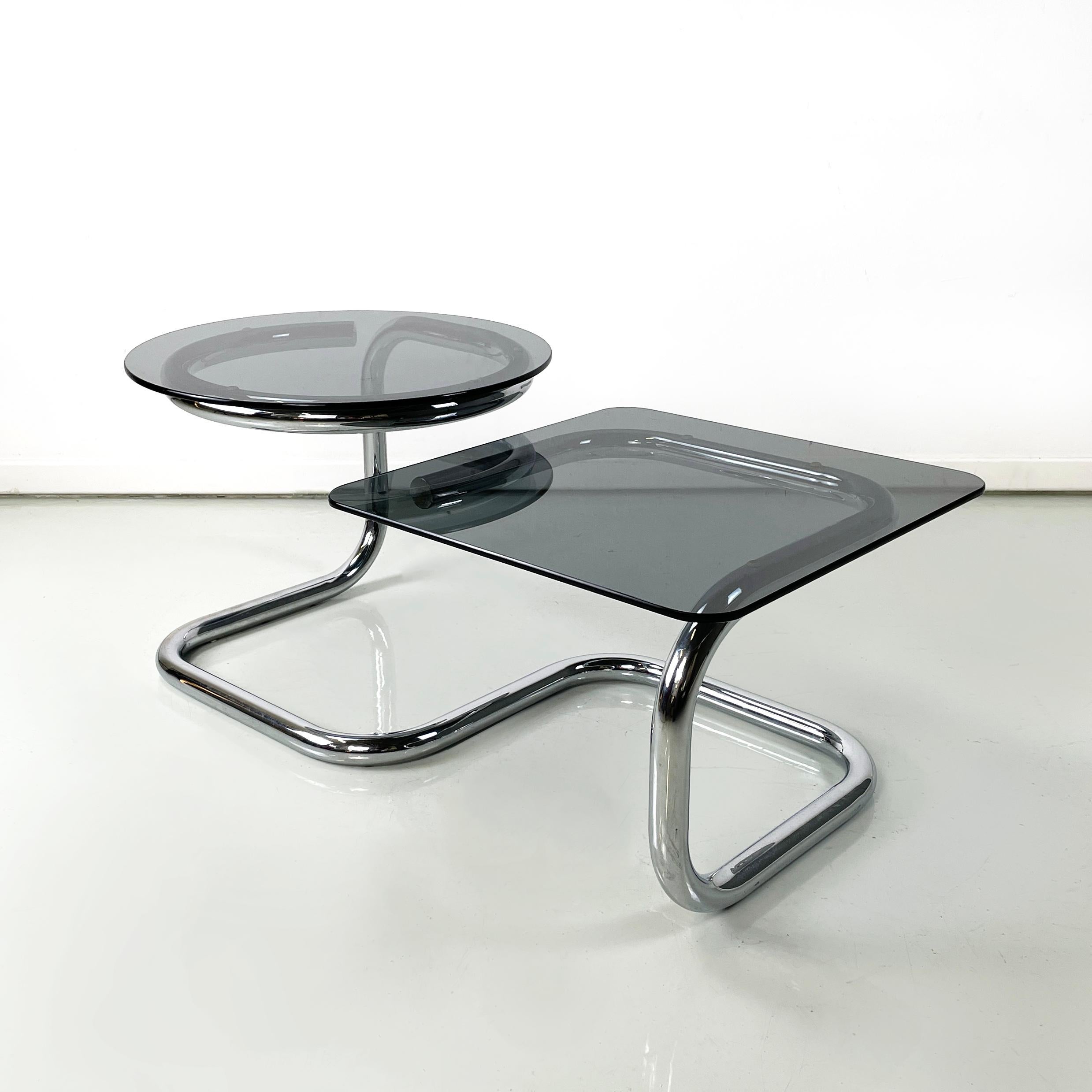 Italian modern Square and round coffee table in smoked glass and chromed steel, 1970s
Coffee table with double smoked glass shelves. The two tops have both different heights and shapes, indeed one is round and higher, the other is square and lower.