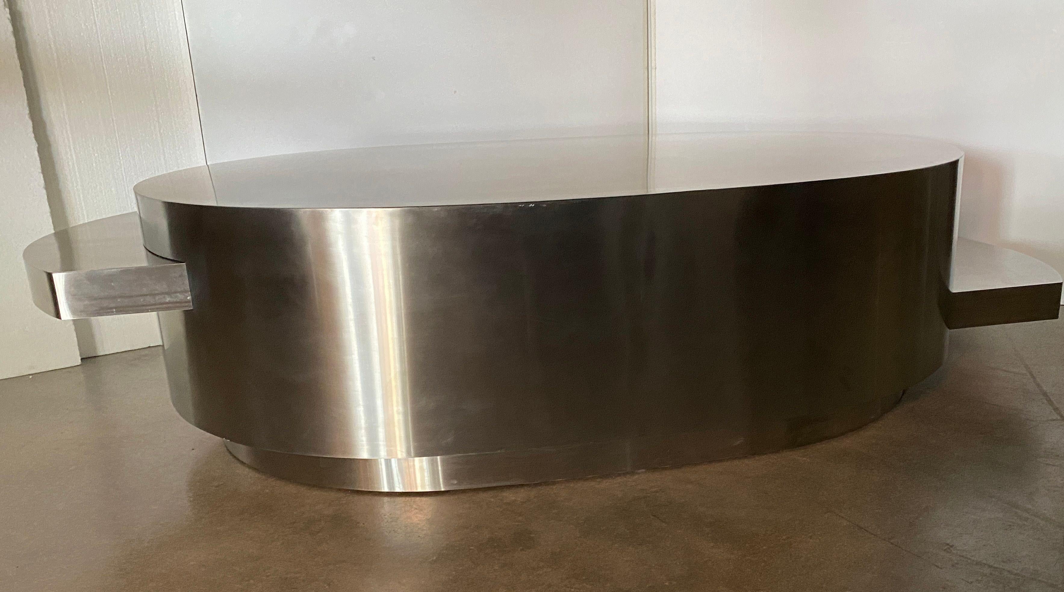 A rare stainless steel coffee table by Gabriella Crespi. Likely an early Ellisse model from the from the Plurimi series. The oval body done in stainless steel with 2 sliding elliptical tops in stainless steel. Extends from 51