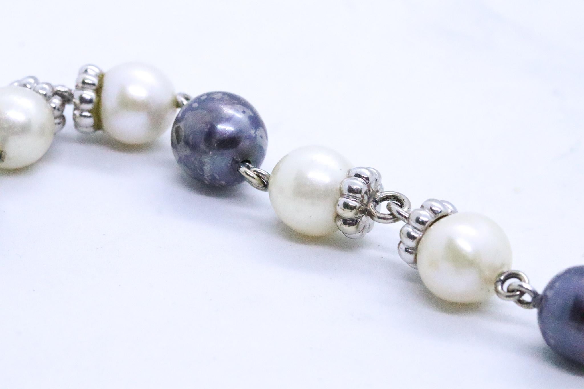Modern stations necklace with Pearls.

Beautiful and versatile necklace, carefully crafted in Vicenza, Italy in solid white gold of 14 karats.  Mounted with 9 Tahitian round black pearls of 11.5 mm and 18 white round pearls of 10 mm.

Has a total
