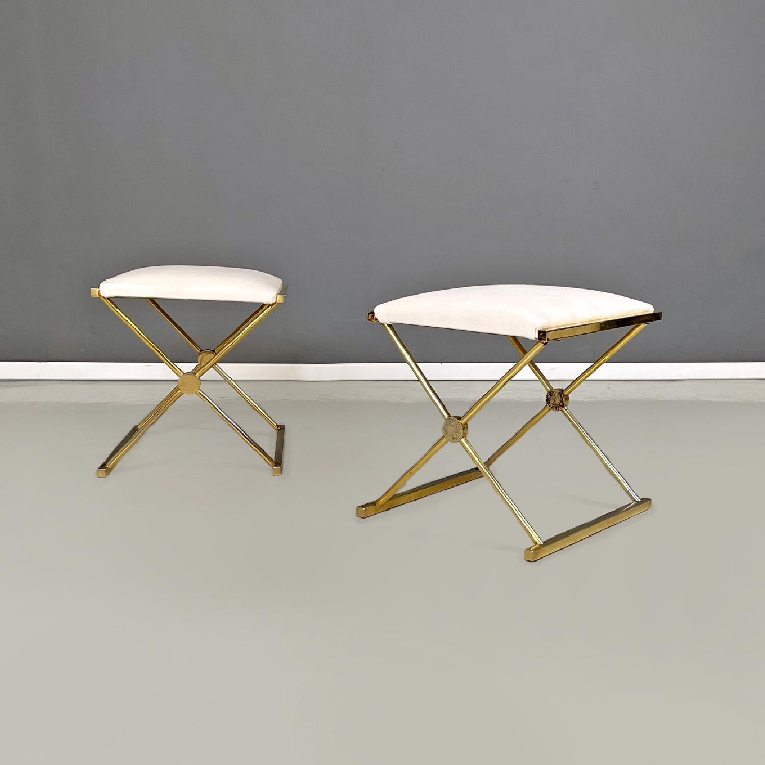Italian modern stools in golden metal and white fabric, 1980s
Set of four stools with padded rectangular seat covered in white fabric. The structure, in metal with a golden finish, crosses on two sides to form the legs and the floor