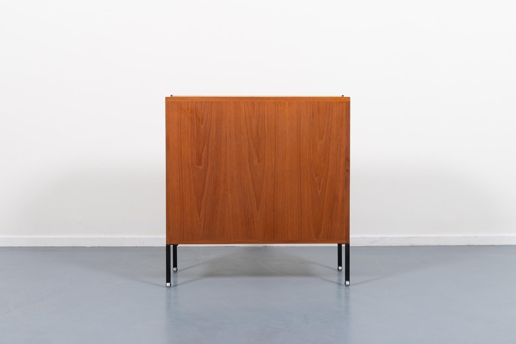 Architectural Italian Modern free standing credenza/storage cabinet from 1960’s designed by Ico Parisi for MIM. It features a flap door covered in beige velvet fabric, shelf and and storage space behind it. Equipped with black coated steel legs and