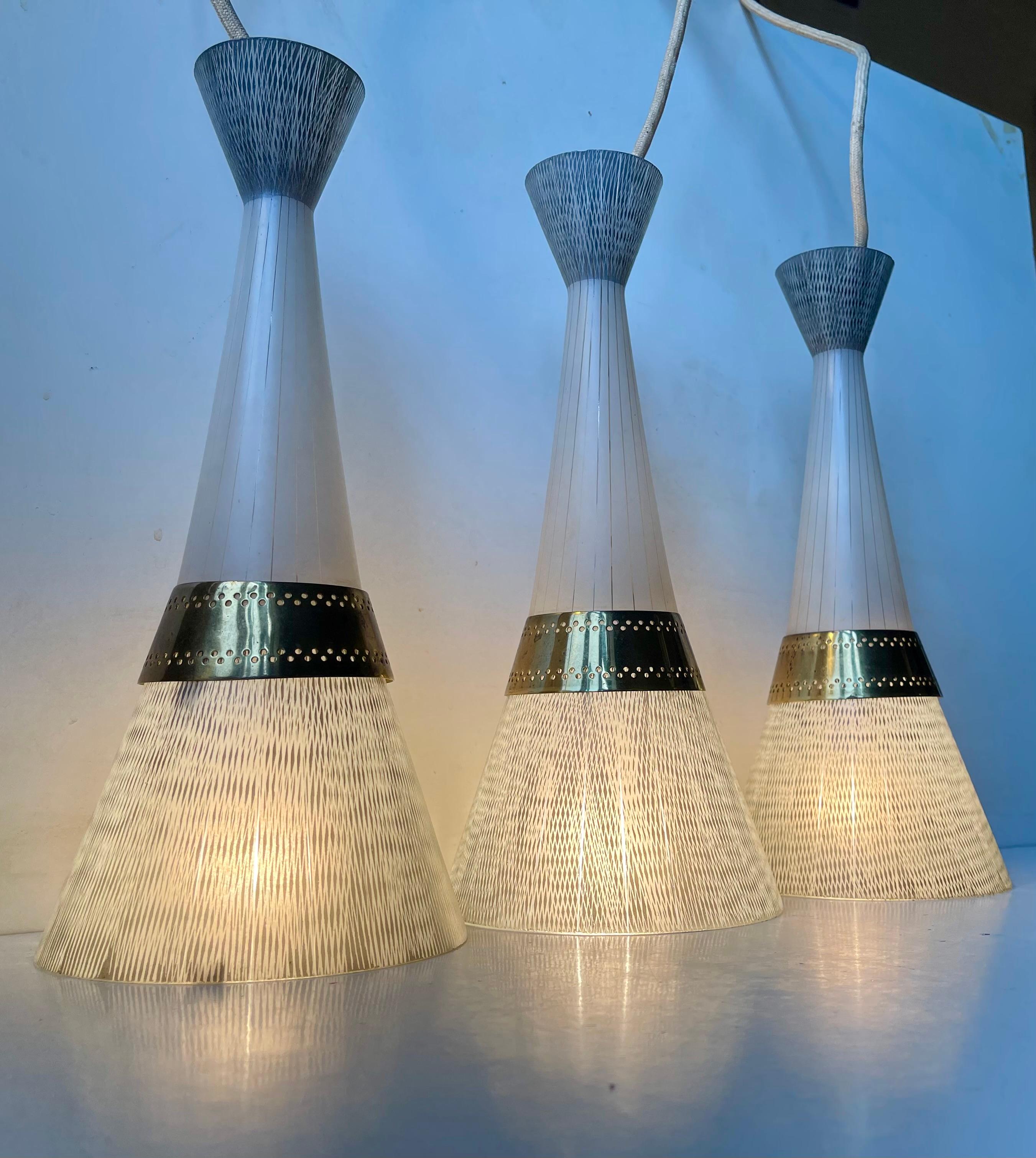 Stilvolle Diablo Trio Hängeleuchte mit 3 geätzten Glasschirmen. Das Glas weist handgravierte Muster auf, die von der Sgraffito-Technik abgeleitet sind und an die Flügelstruktur von Schmetterlingen erinnern. Die Oberseite der Schirme aus mattem Glas