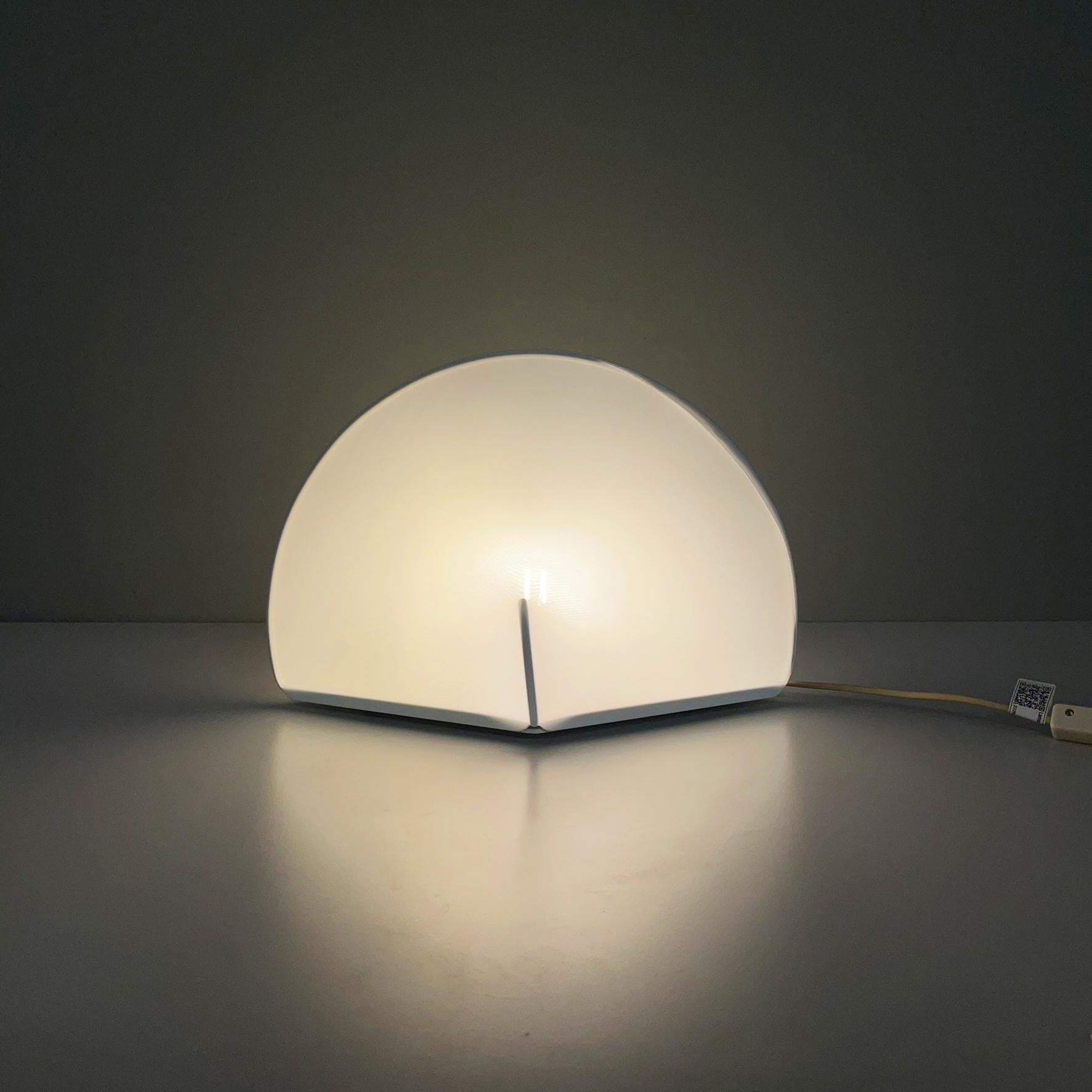 Italian modern table lamp mod. Kaori 2 by Kazuhide Takahama for Sirrah, 1970s.
Table or bedside lamp mod. Kaori 2 with rhomboidal base in white metal. The structure is composed of a metal arch. The lampshade is made of white stretch jersey fabric,