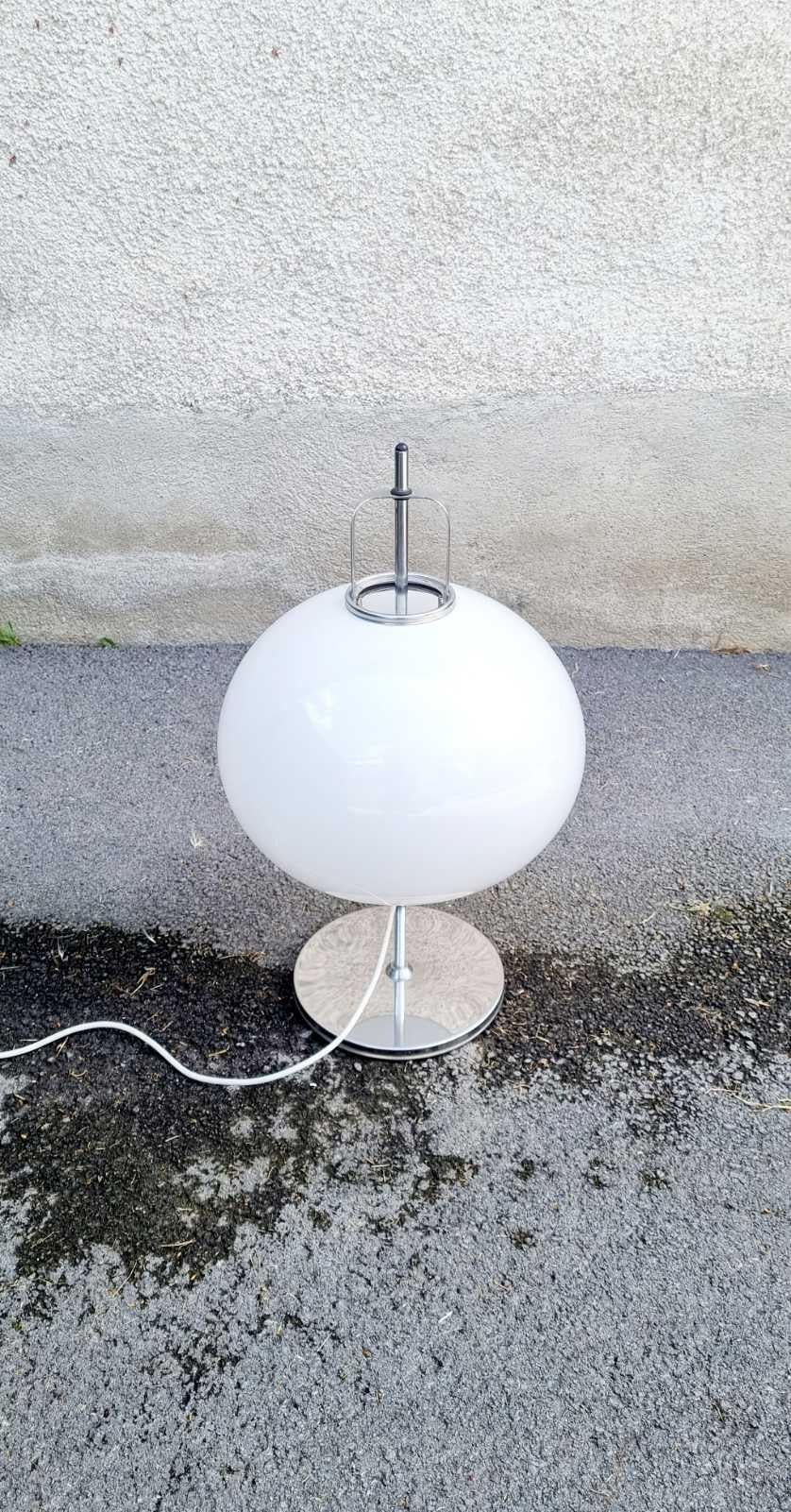Design: Luigi Massoni per Harvey Guzzini, Italia 1966
Produttore: Meblo di Nova Gorica, Slovenia, ex Jugoslavia.
Si tratta di un modello Lucerna
Si compone di una base in metallo cromato e di un supporto con un paralume a sfera in acrilico bianco.